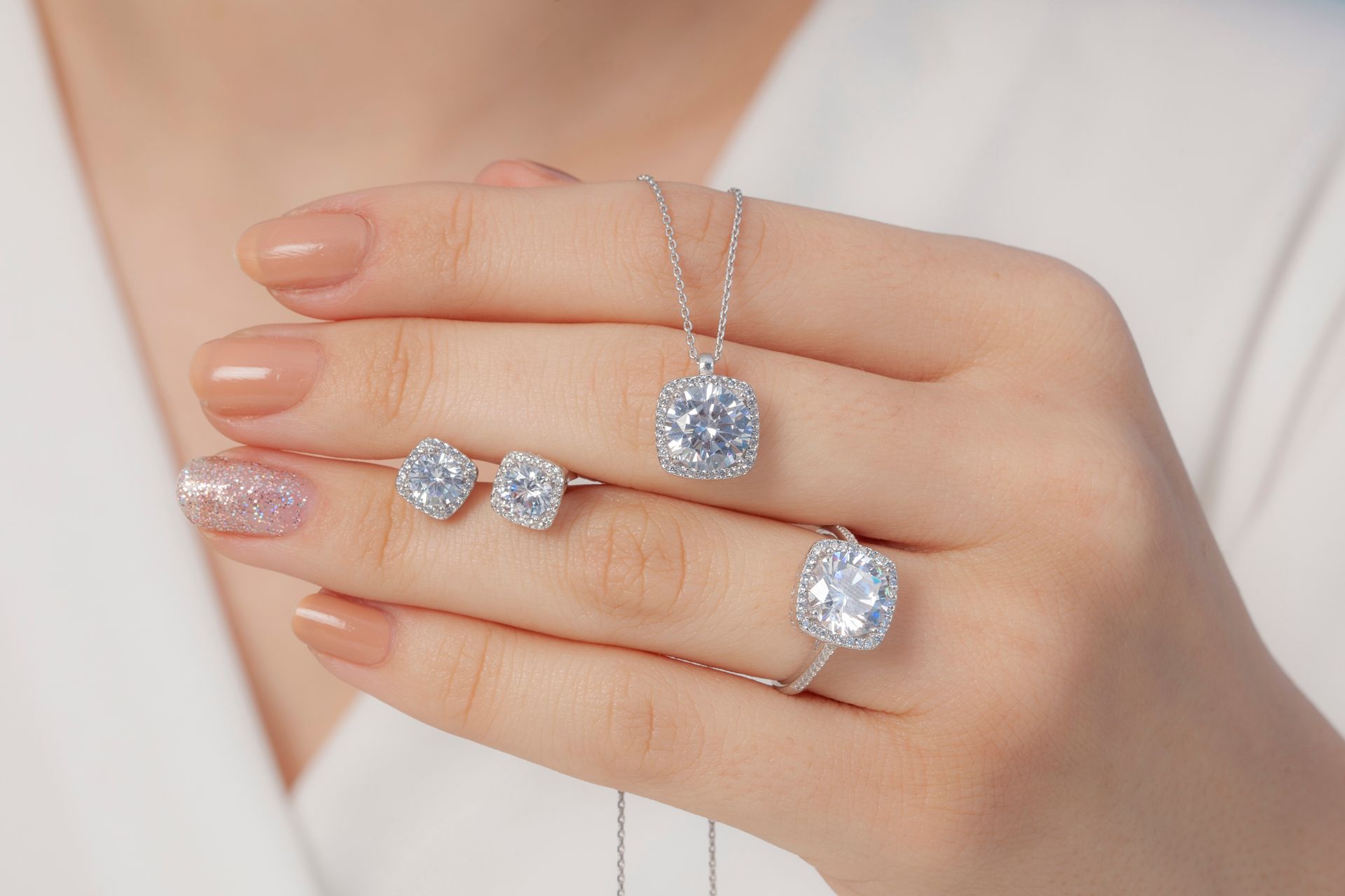 Woman's hand showcasing a diamond jewelry set