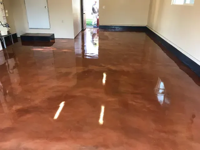 Glossy brown floor in an empty room with white walls and windows.