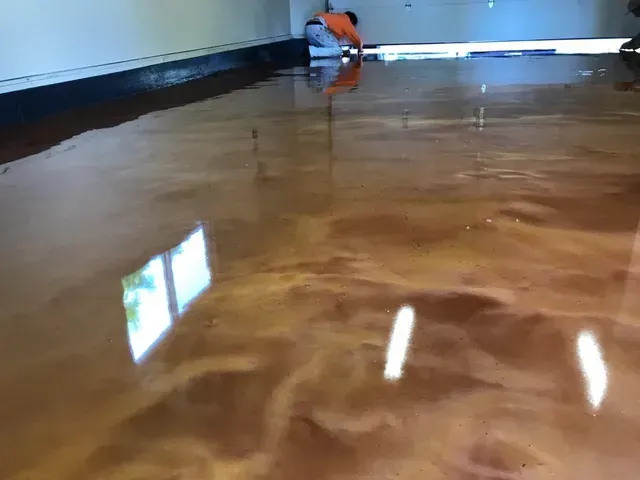 Shiny flooded floor in a room, with a small orange object near the back wall.