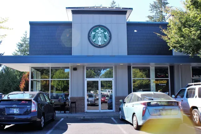 Starbucks storefront with parked cars in front