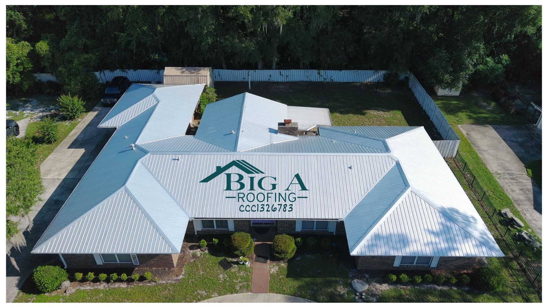 Aerial view of a residential house roof with a white metal finish and the Big A Roofing company logo printed in the center.