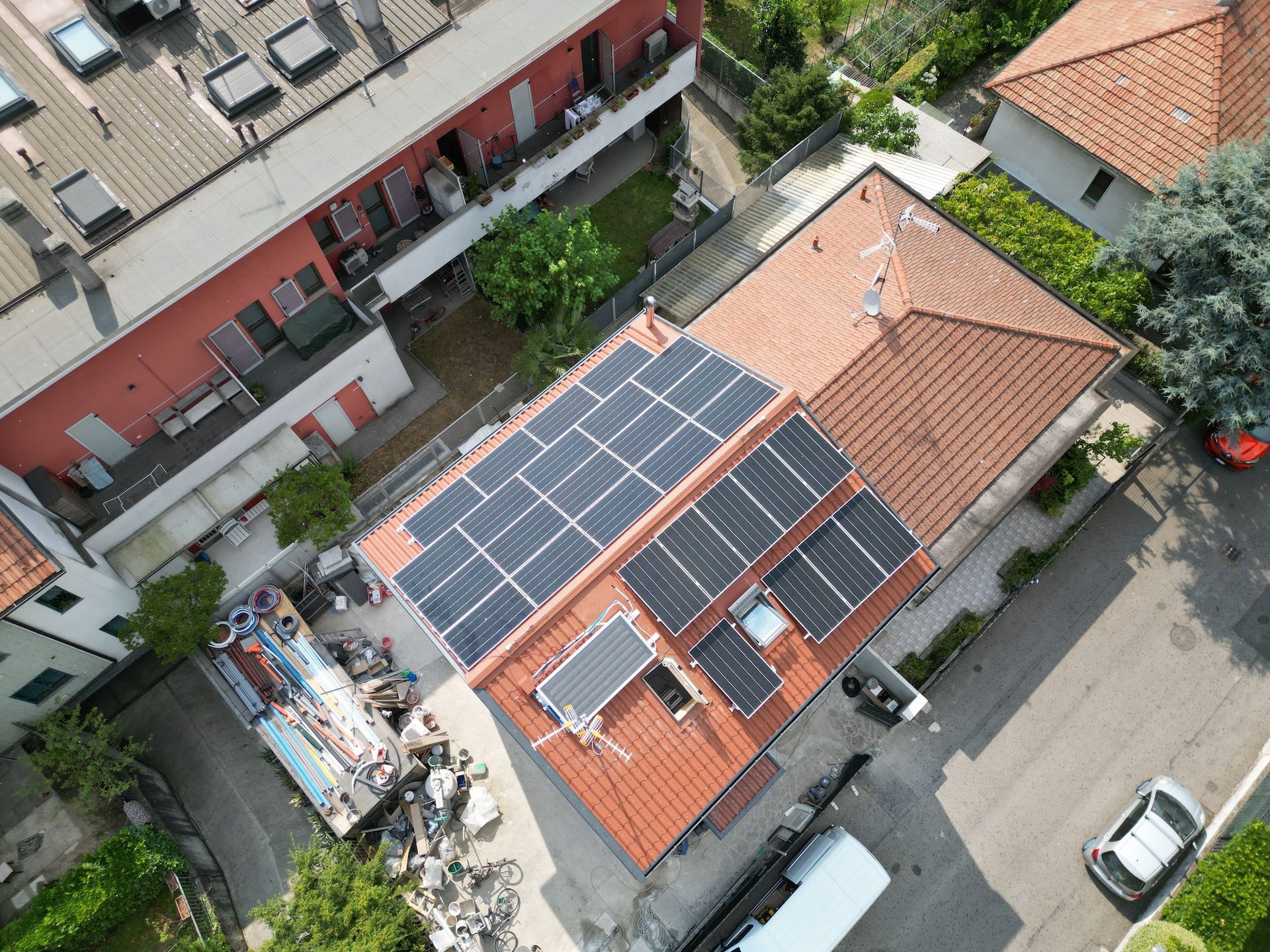 Vista aerea dei tetti residenziali con pannelli solari; giornata di sole.