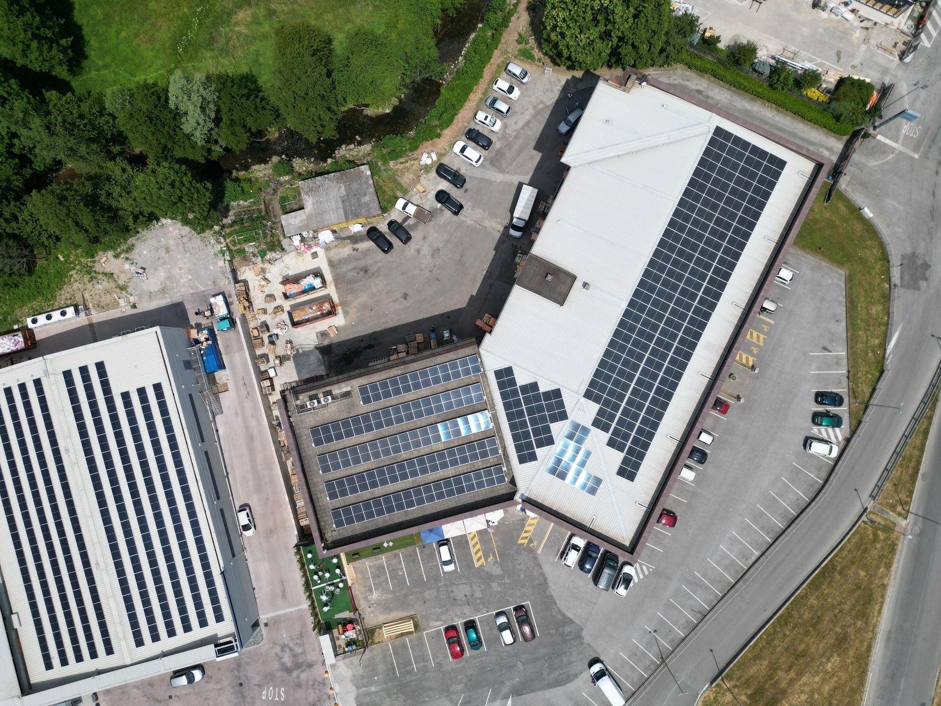 Vista aerea: edifici con pannelli solari sui tetti e aree di parcheggio circostanti.