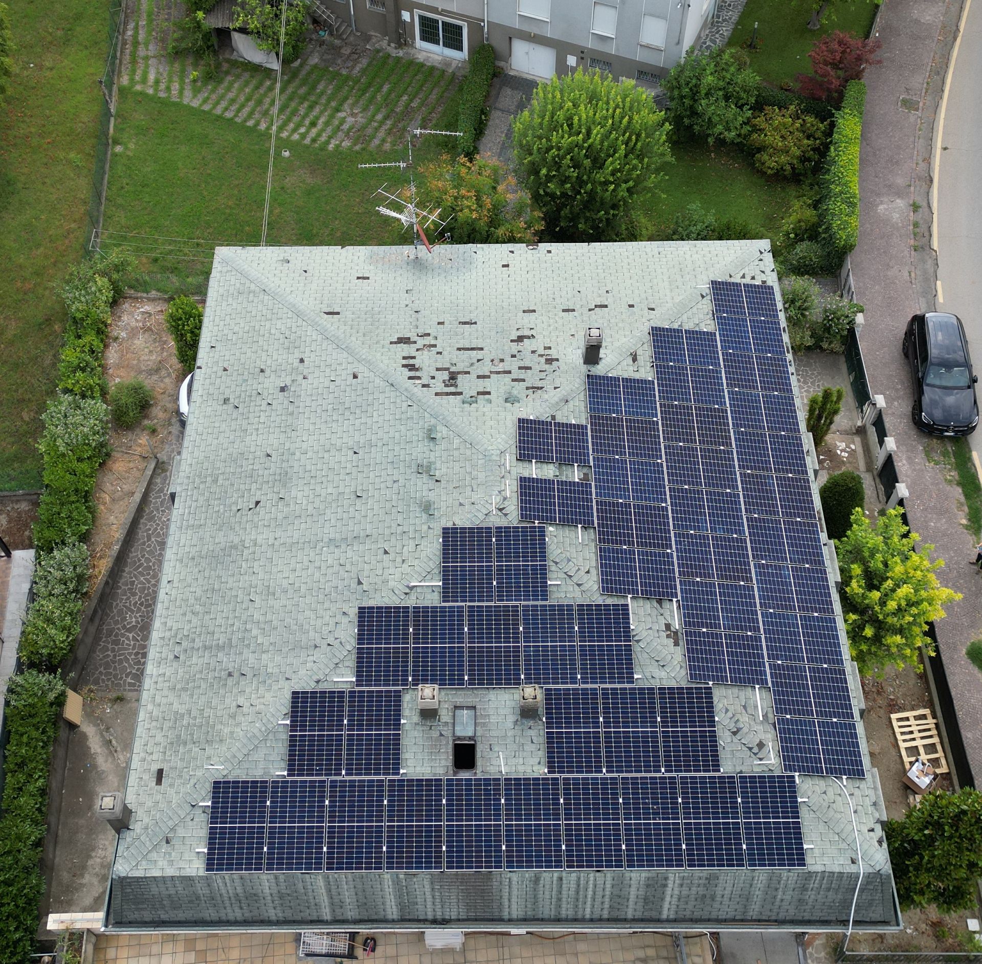 Vista aerea del tetto di una casa con pannelli solari installati secondo una disposizione geometrica.