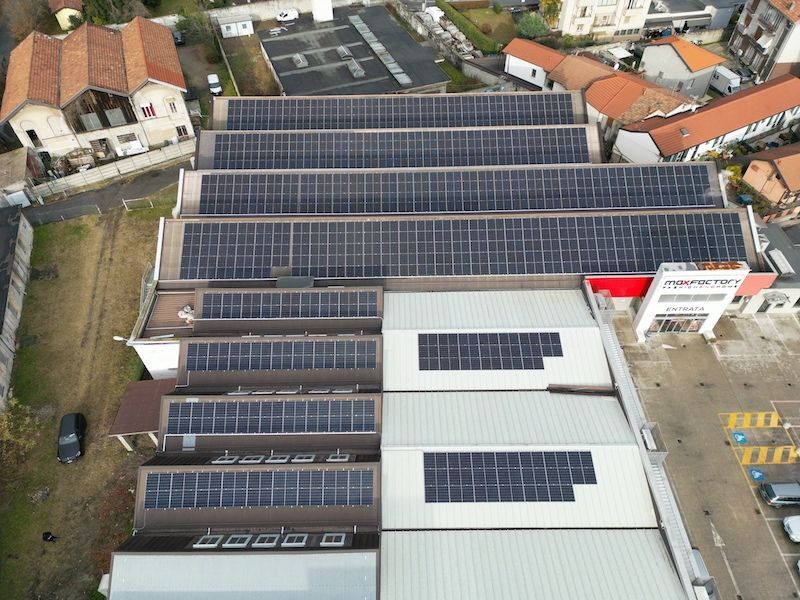 Vista aerea del tetto di un edificio ricoperto da file di pannelli solari.