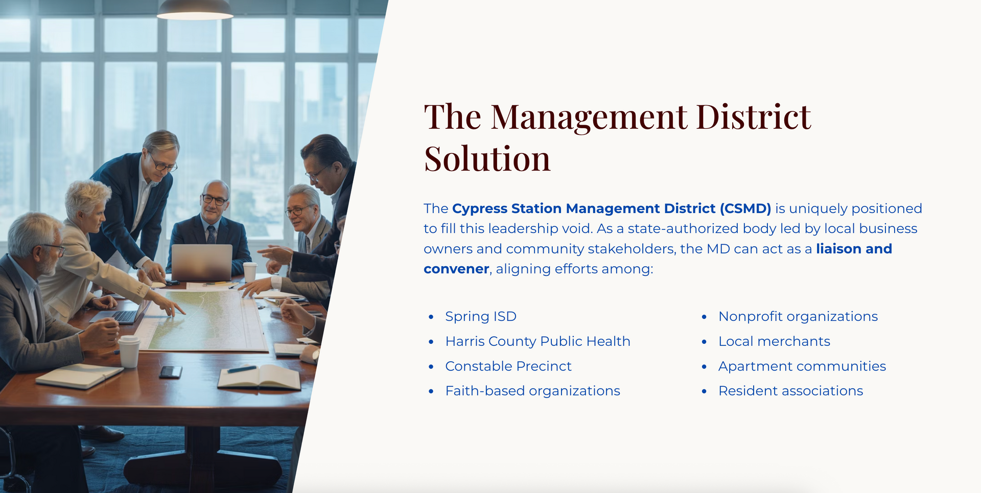 Business meeting in a modern office; people around a table looking at a laptop.