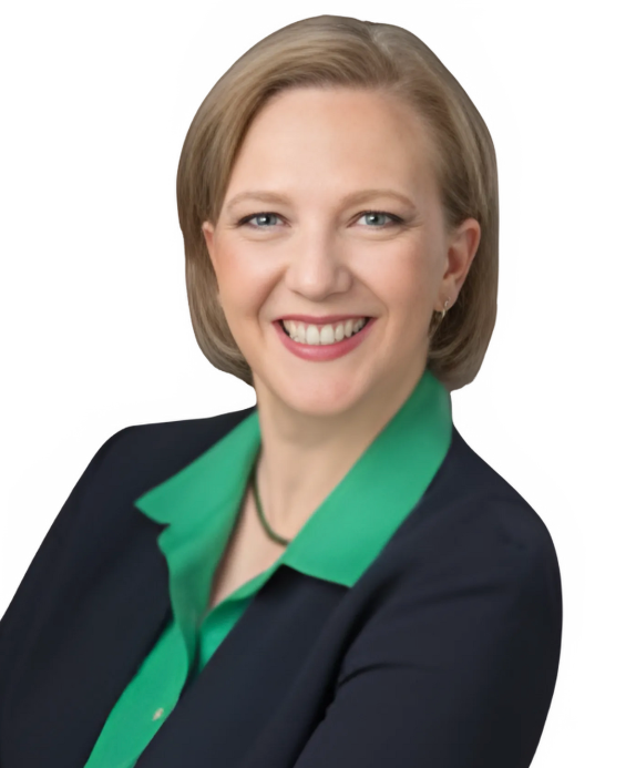 A woman wearing a green shirt and a black jacket smiles for the camera