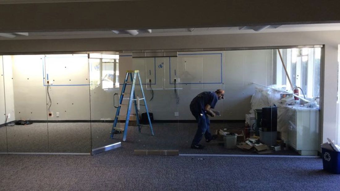 A man is standing in an empty room with a ladder.