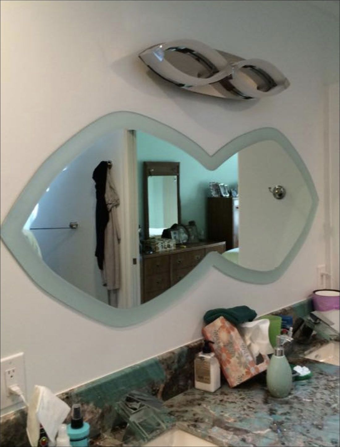 A bathroom with a heart shaped mirror on the wall
