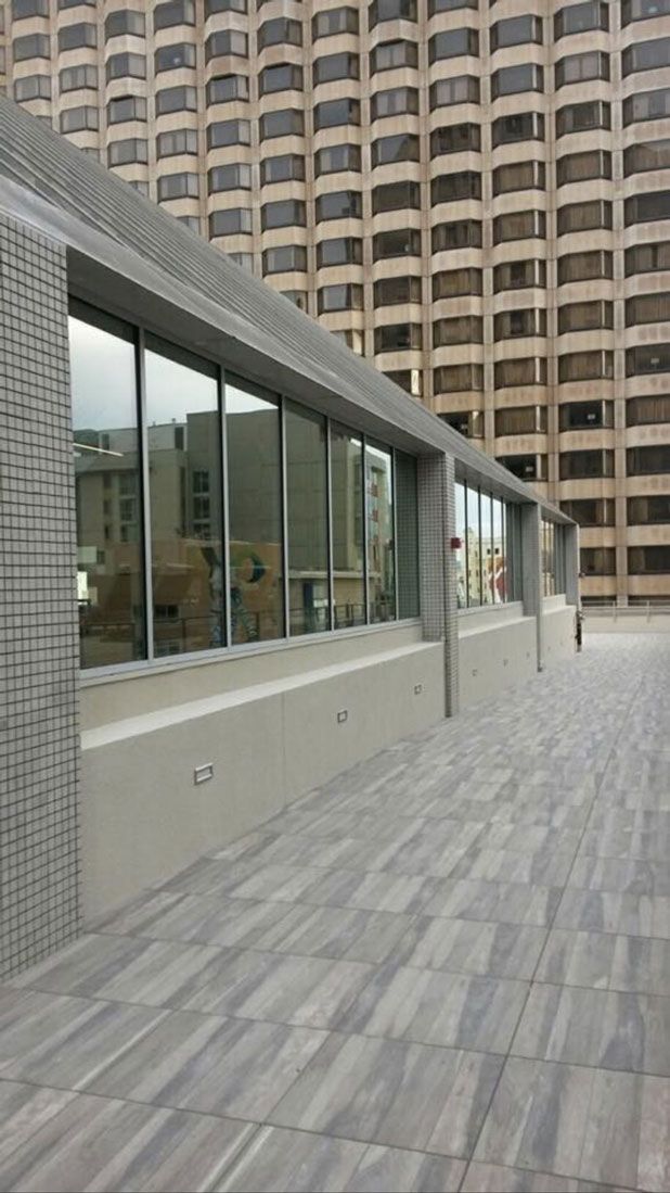 A large building with a lot of windows and a patio in front of it.
