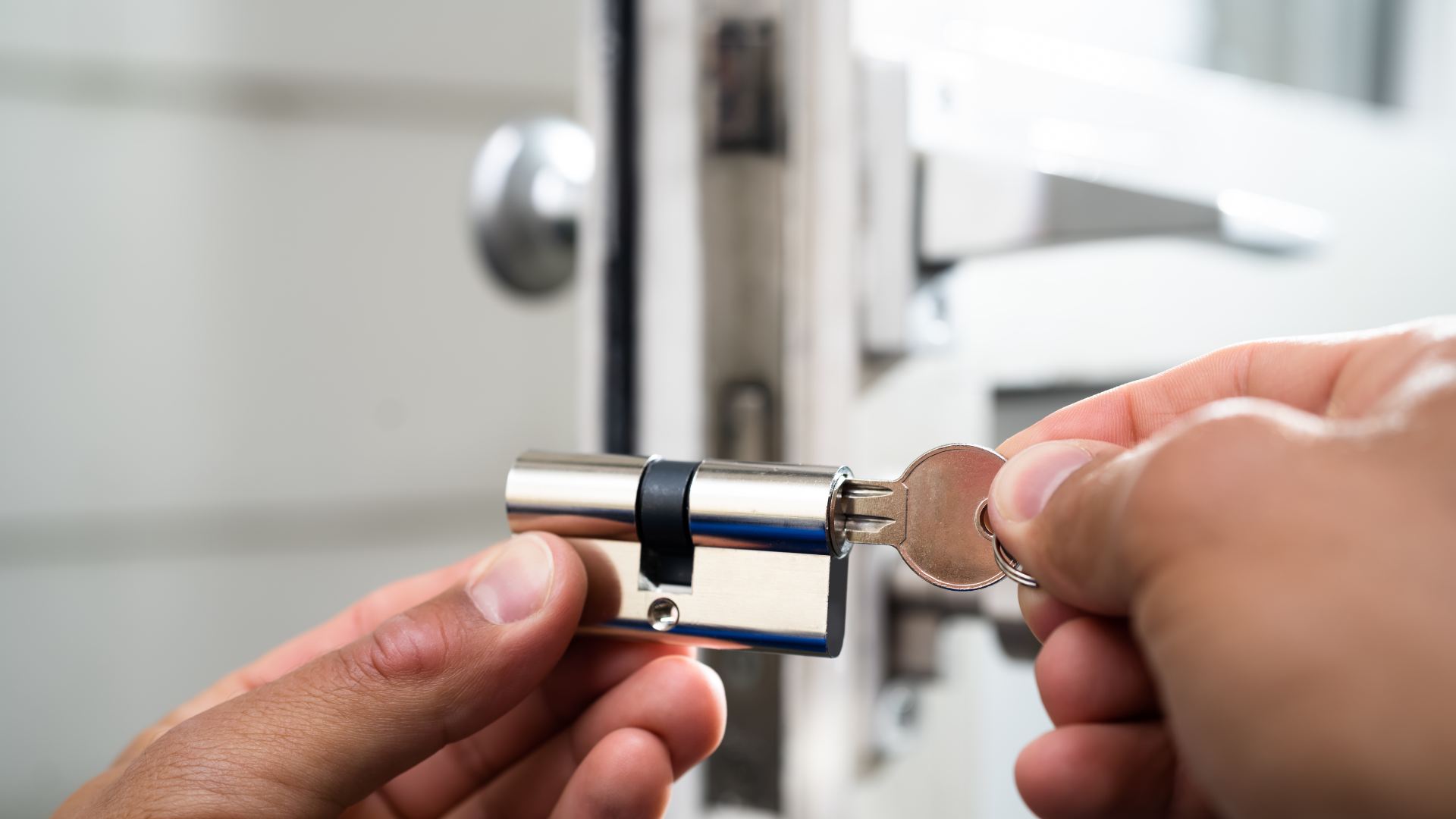 A man is fixing a door lock with a screwdriver