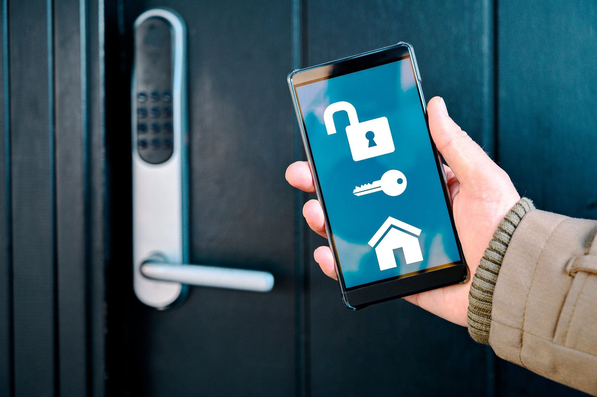A person is holding a smart phone in front of a door