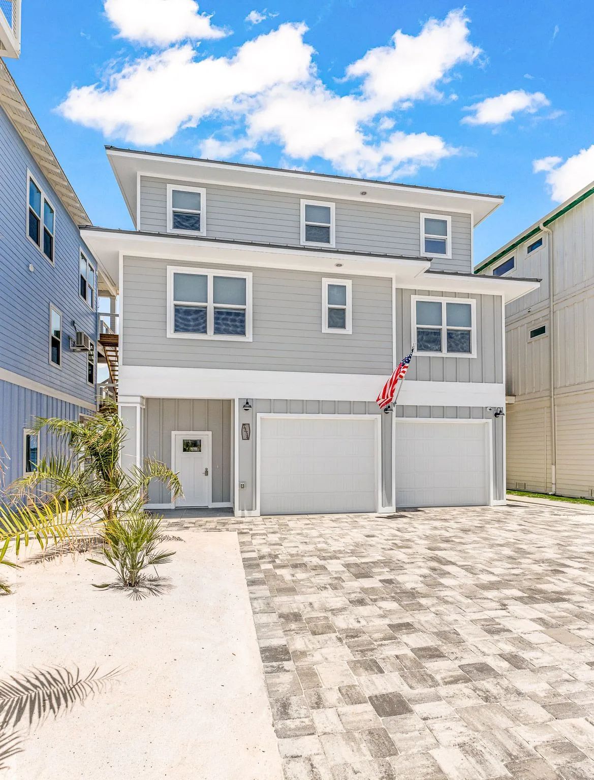 A large gray house with a white garage door