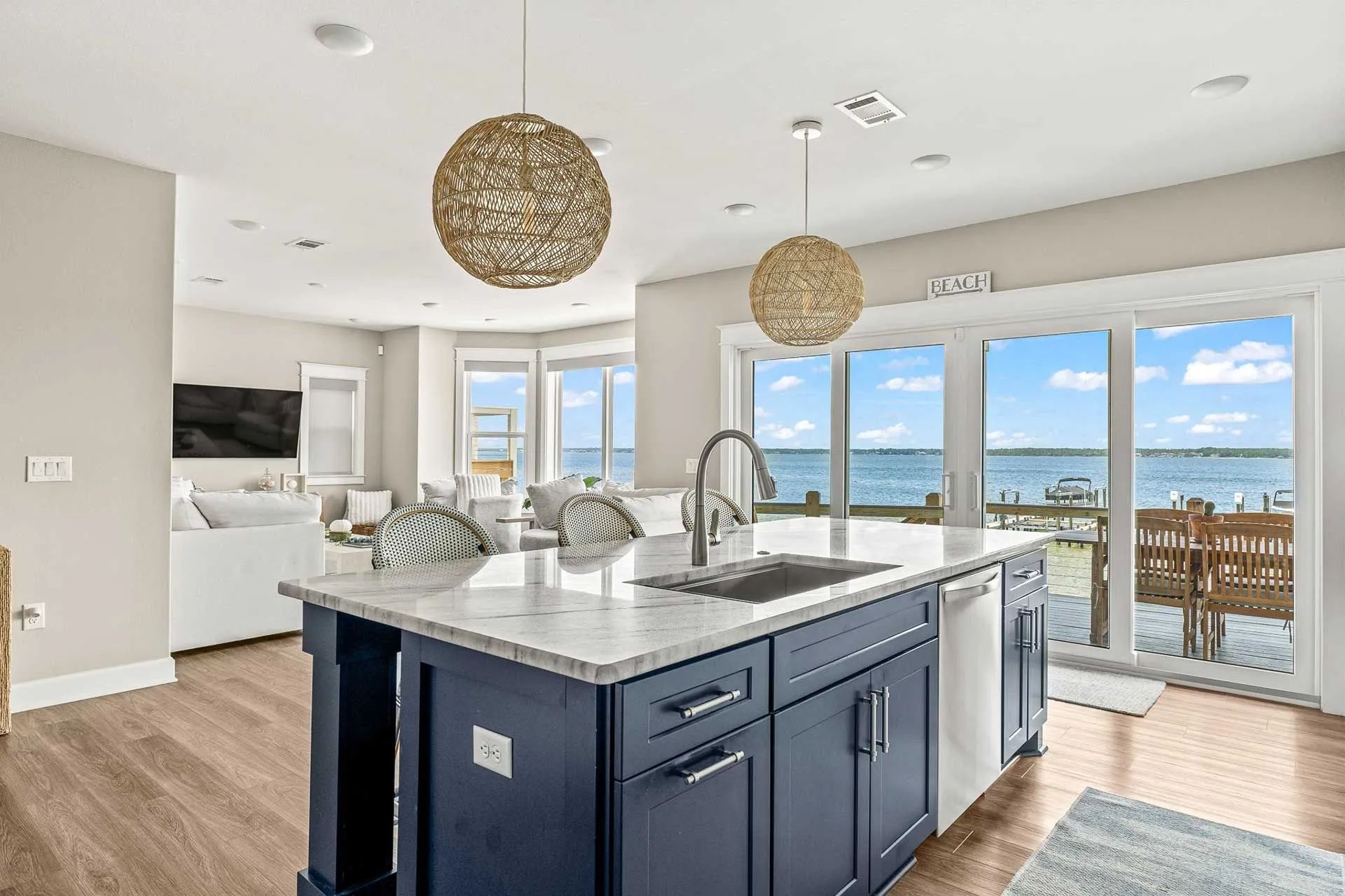 A kitchen with a large island in the middle and a view of the ocean.