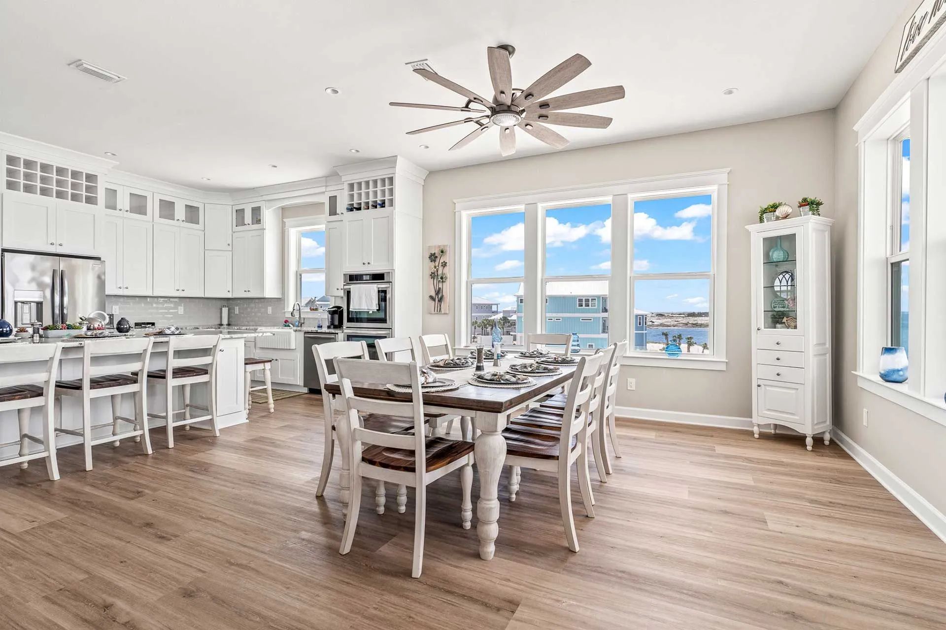 A large living room with a dining table and chairs and a ceiling fan.