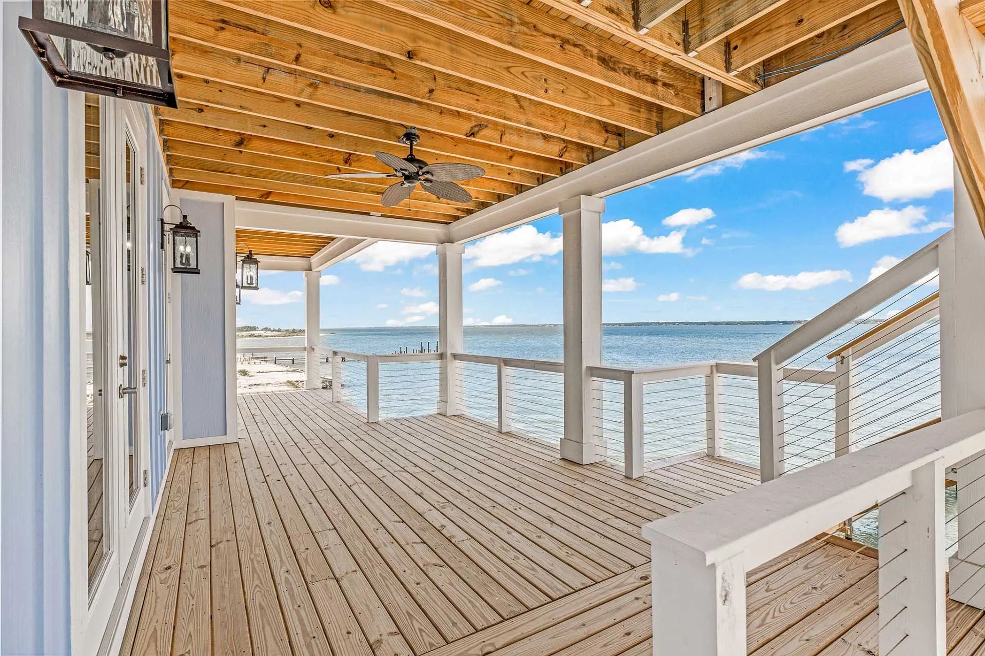 A large wooden deck with a view of the ocean.