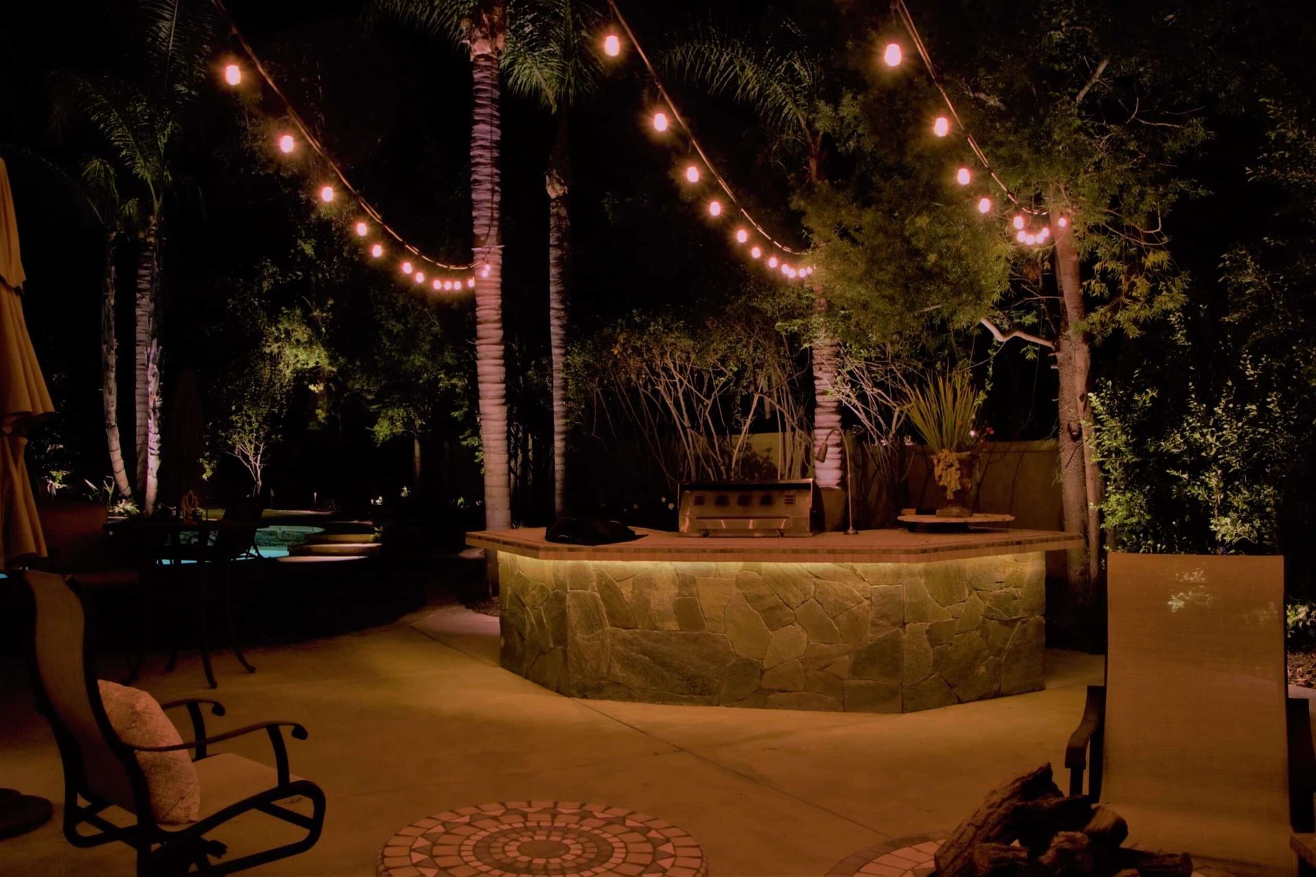 fire pit with bistro lights hung above.