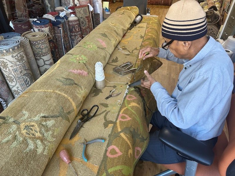 Expert artisan hand-repairing an oriental rug at Rug Master in Berkeley, CA.