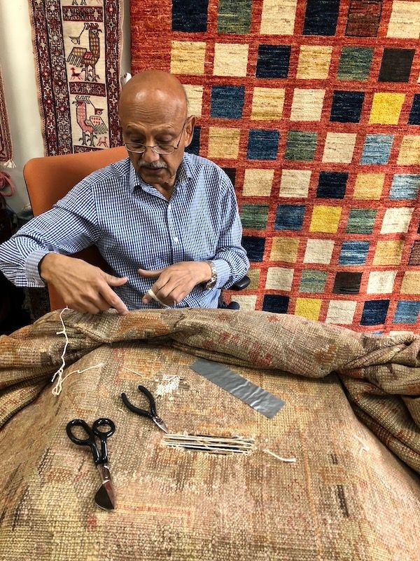 Technician restoring fringe on a handmade rug at Rug Master in Burlingame, CA.