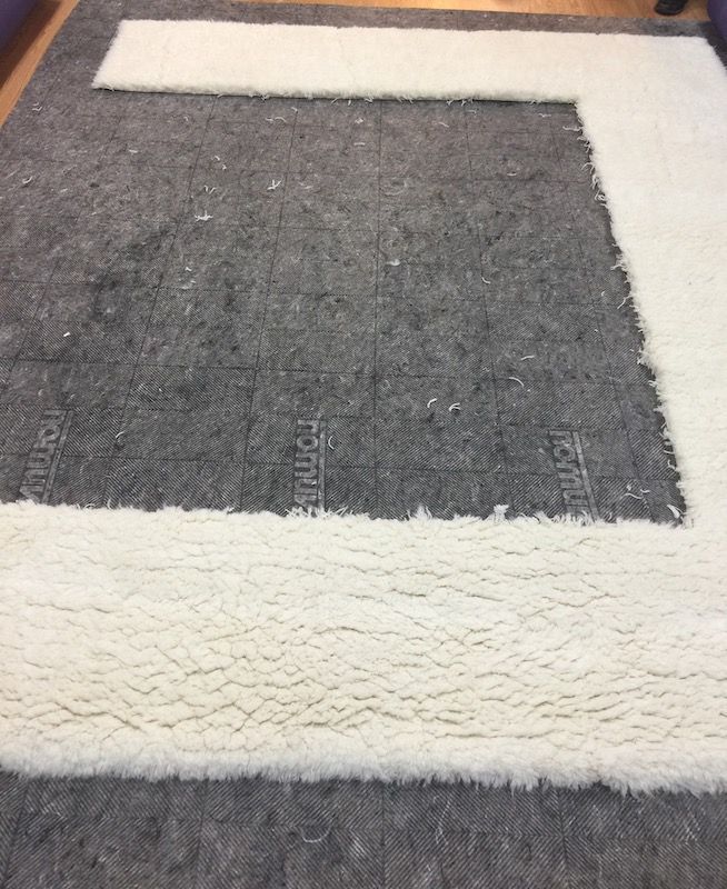 Partially resized rug with clean cut edges and padding, in progress at Rug Master in Burlingame, CA.