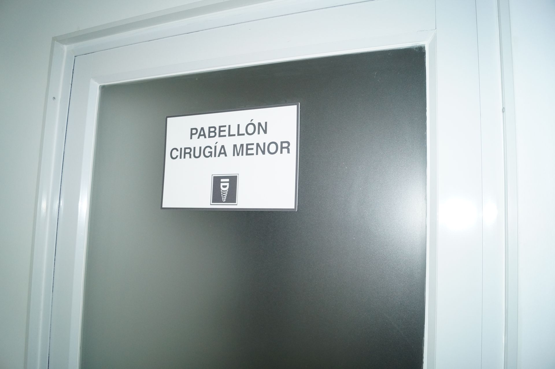 Un consultorio dental con una silla azul y un lavabo.