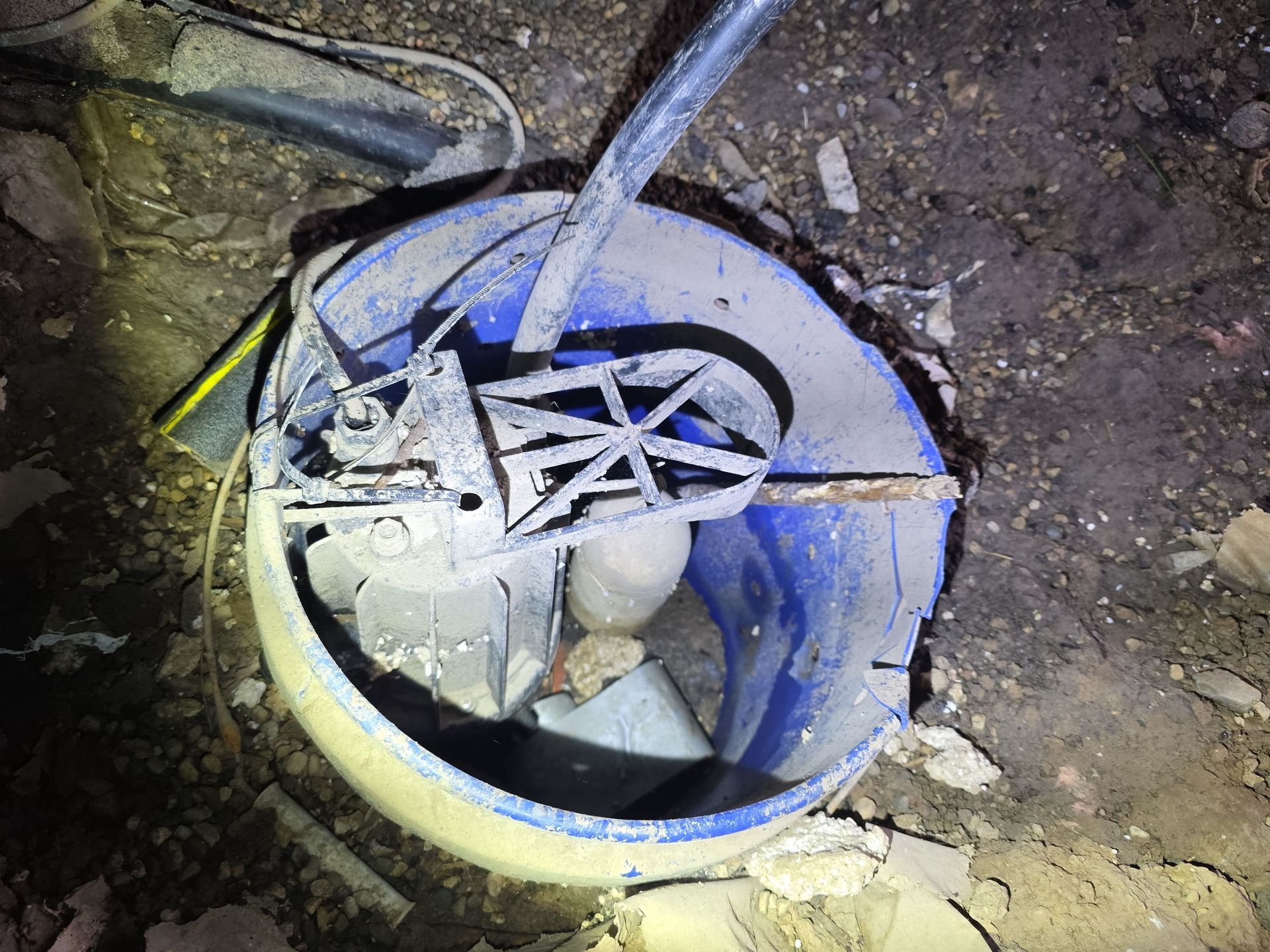 Blue bucket with a mixing tool and electrical wiring.
