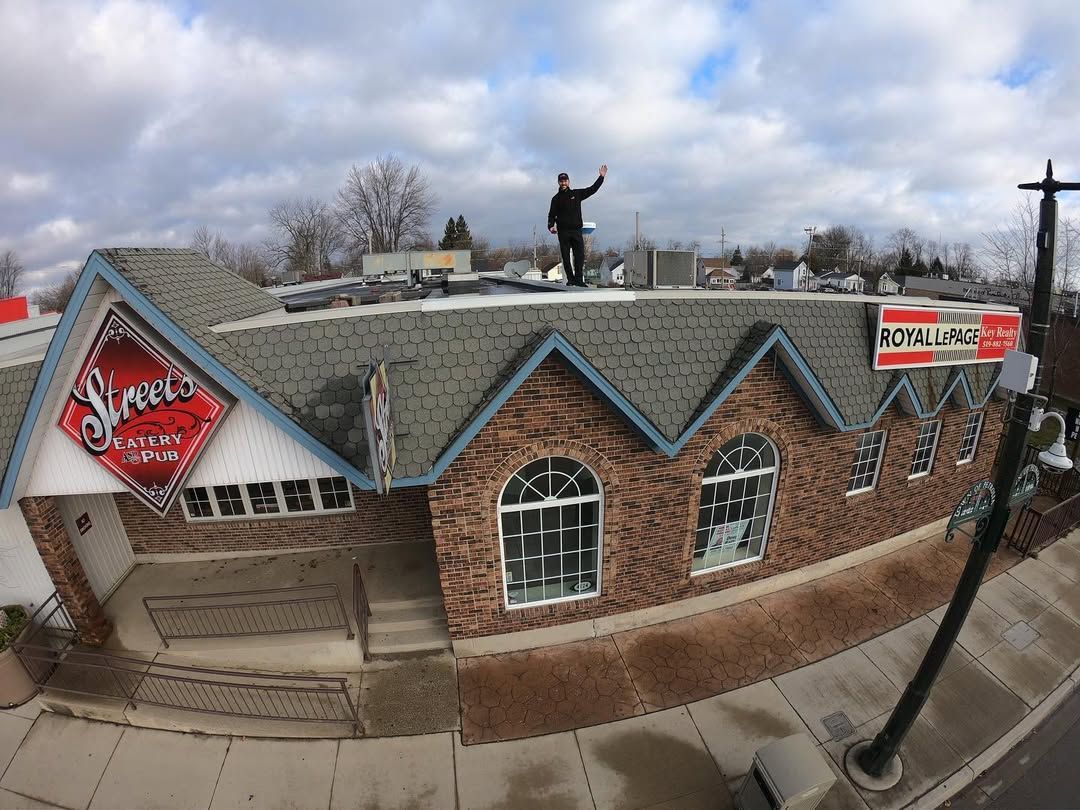 Man on roof of brick building with sign 