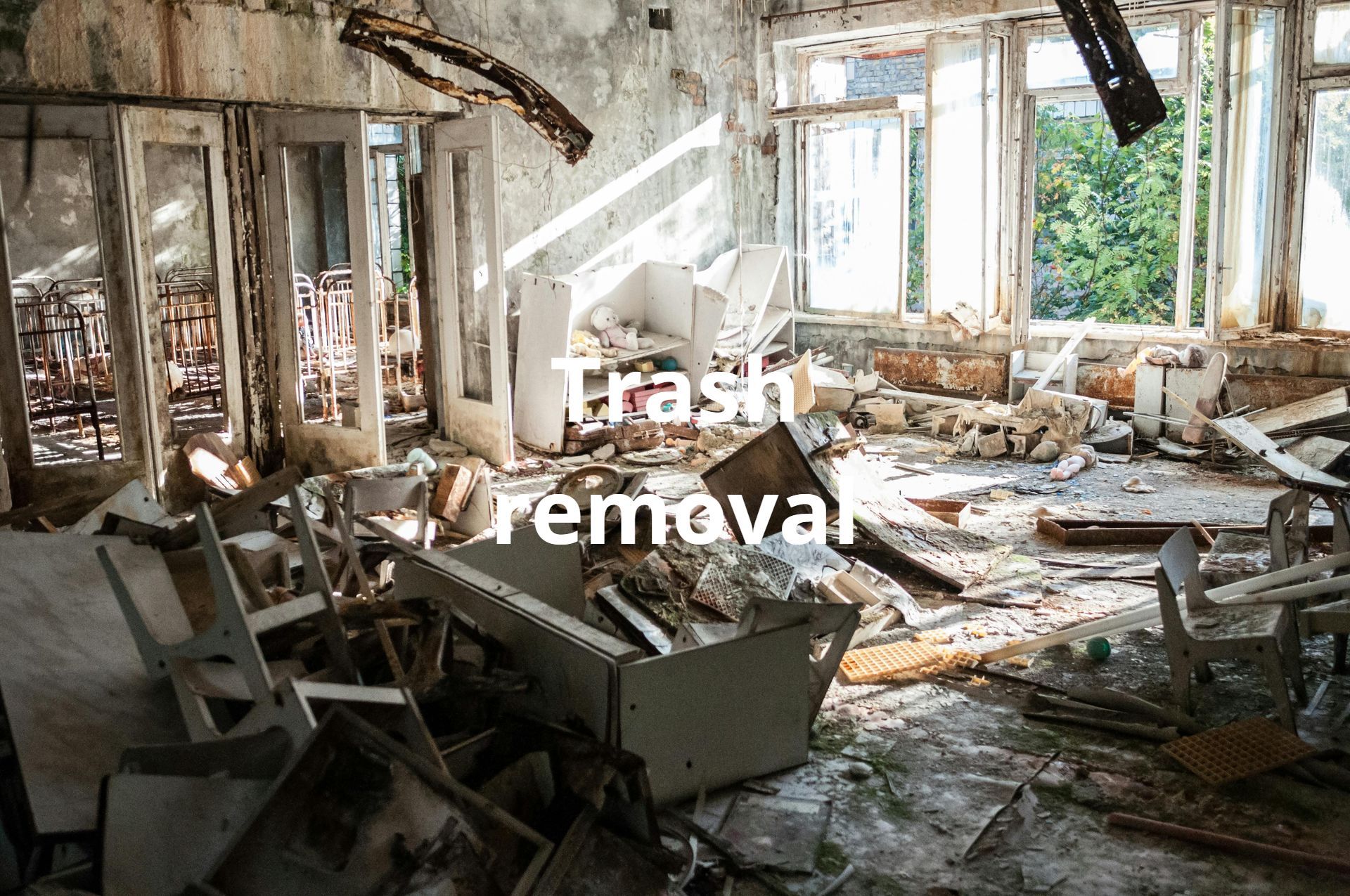 A room filled with lots of trash and a sign that says trash removal.