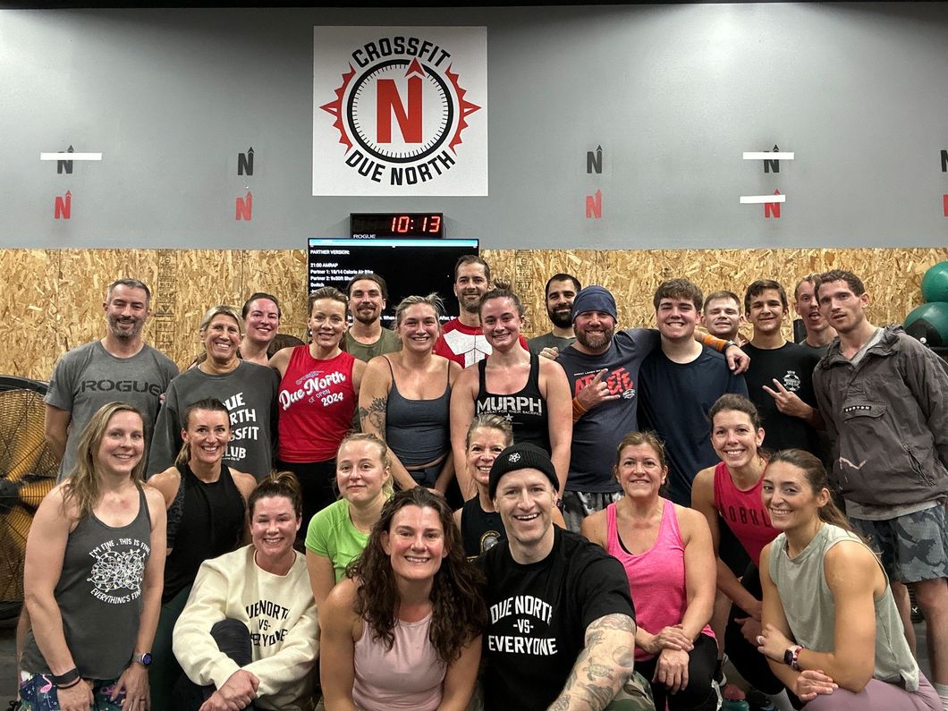 A group of people are posing for a picture in a gym.