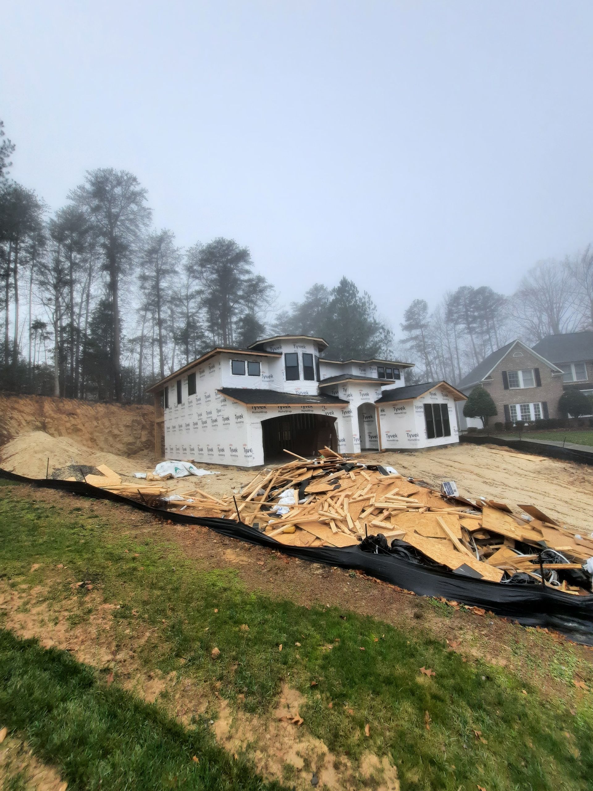 A house is being built on a hill with trees in the background.