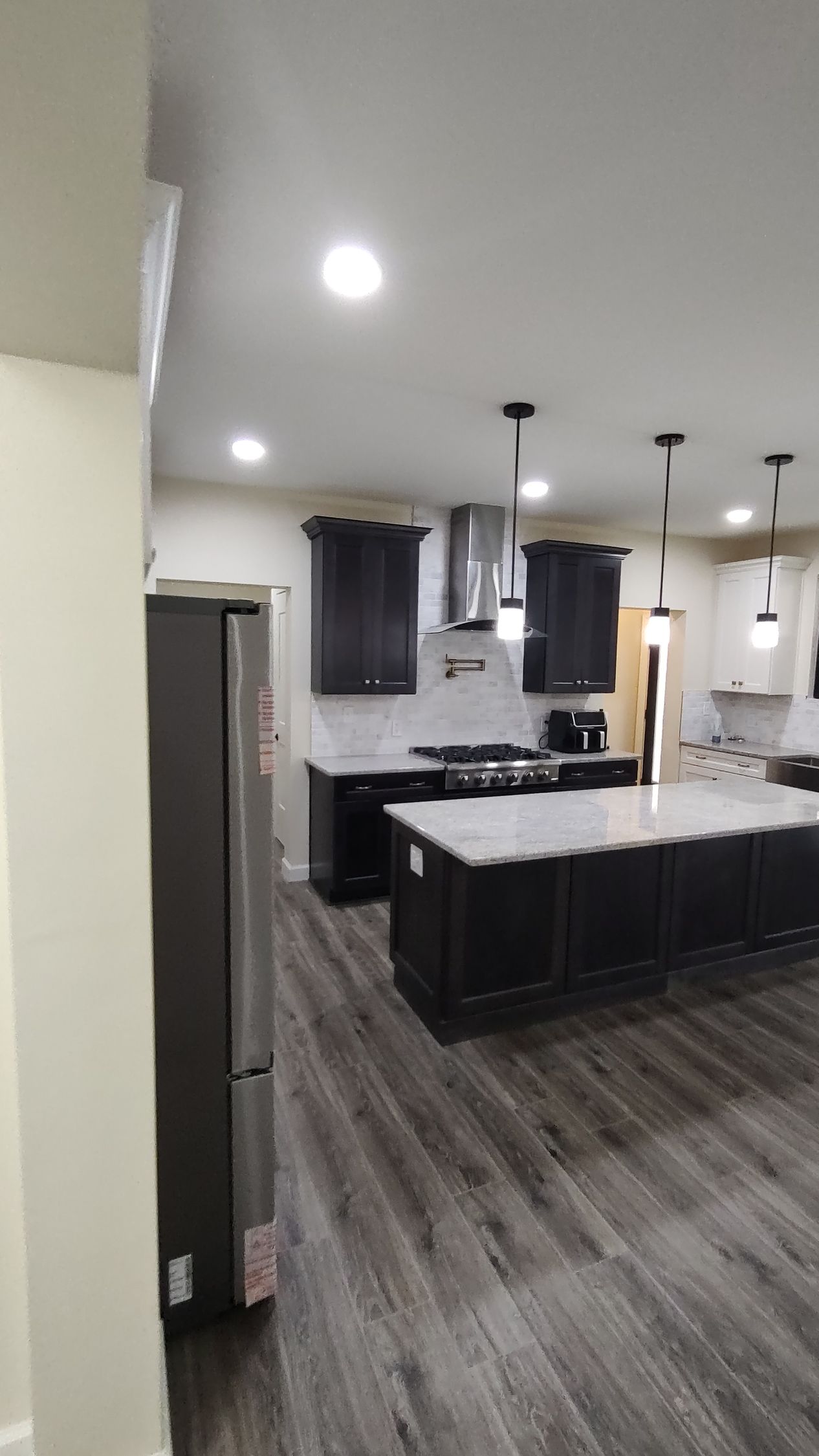 A kitchen with a large island in the middle of it and a refrigerator.