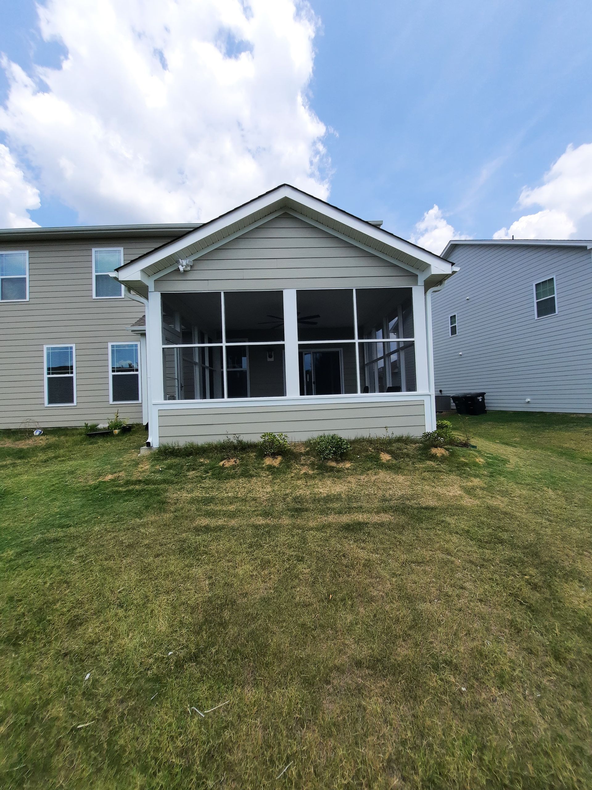 A house with a screened in porch and a lot of windows