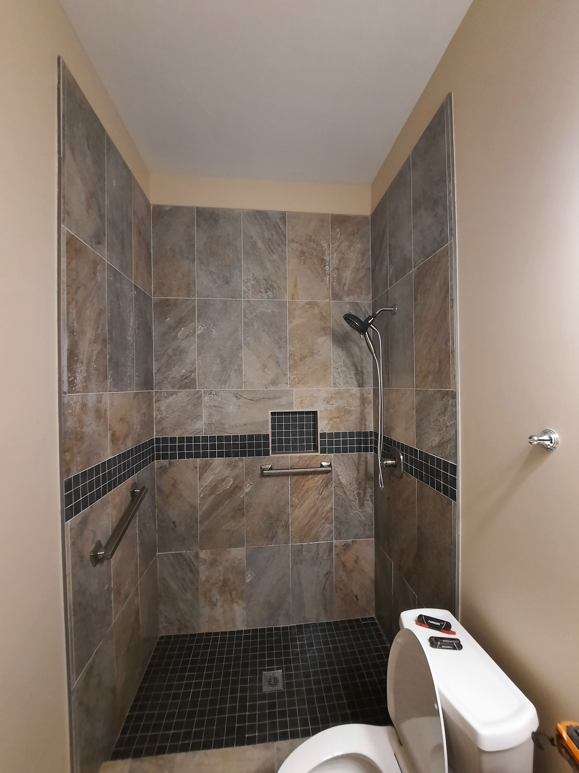 A bathroom with a toilet and a walk in shower