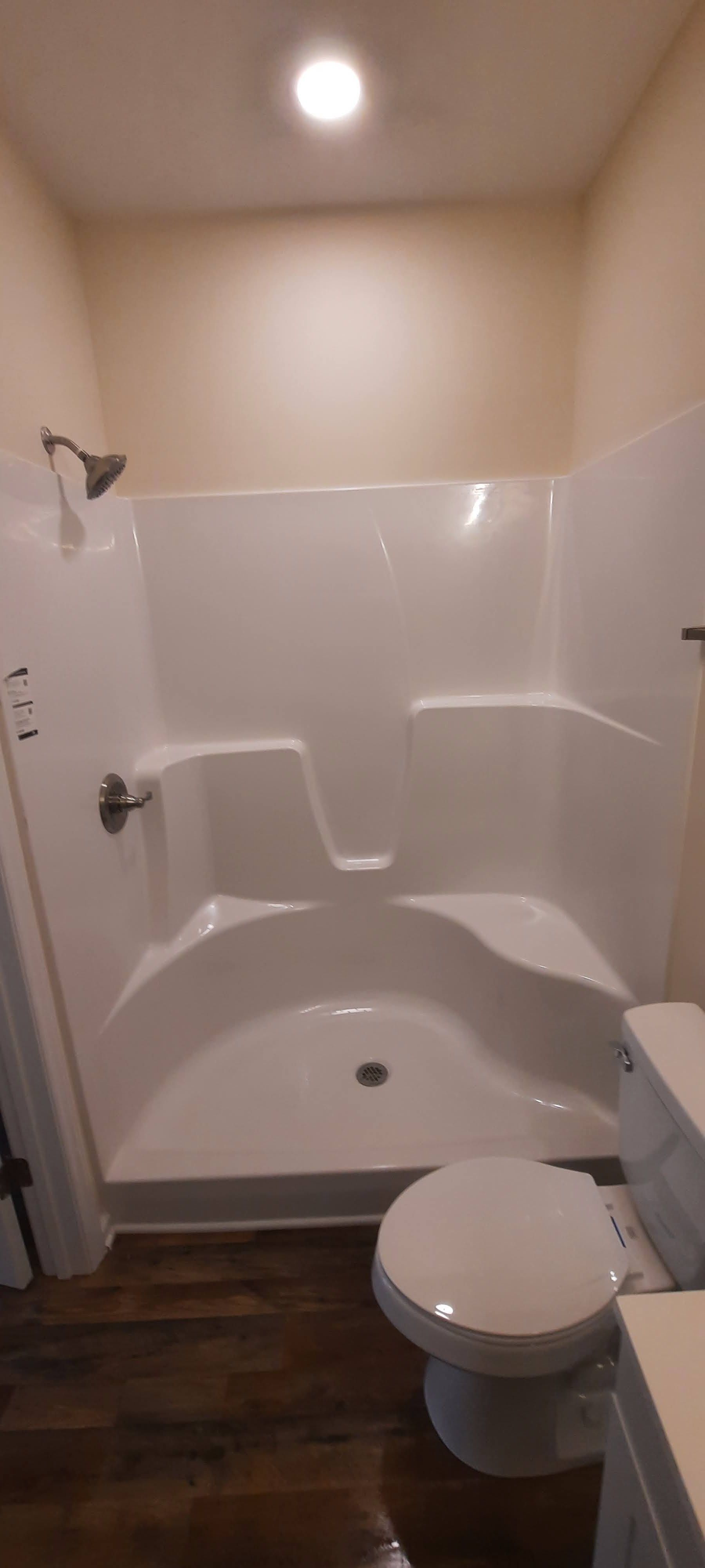A bathroom with a toilet and a shower stall.