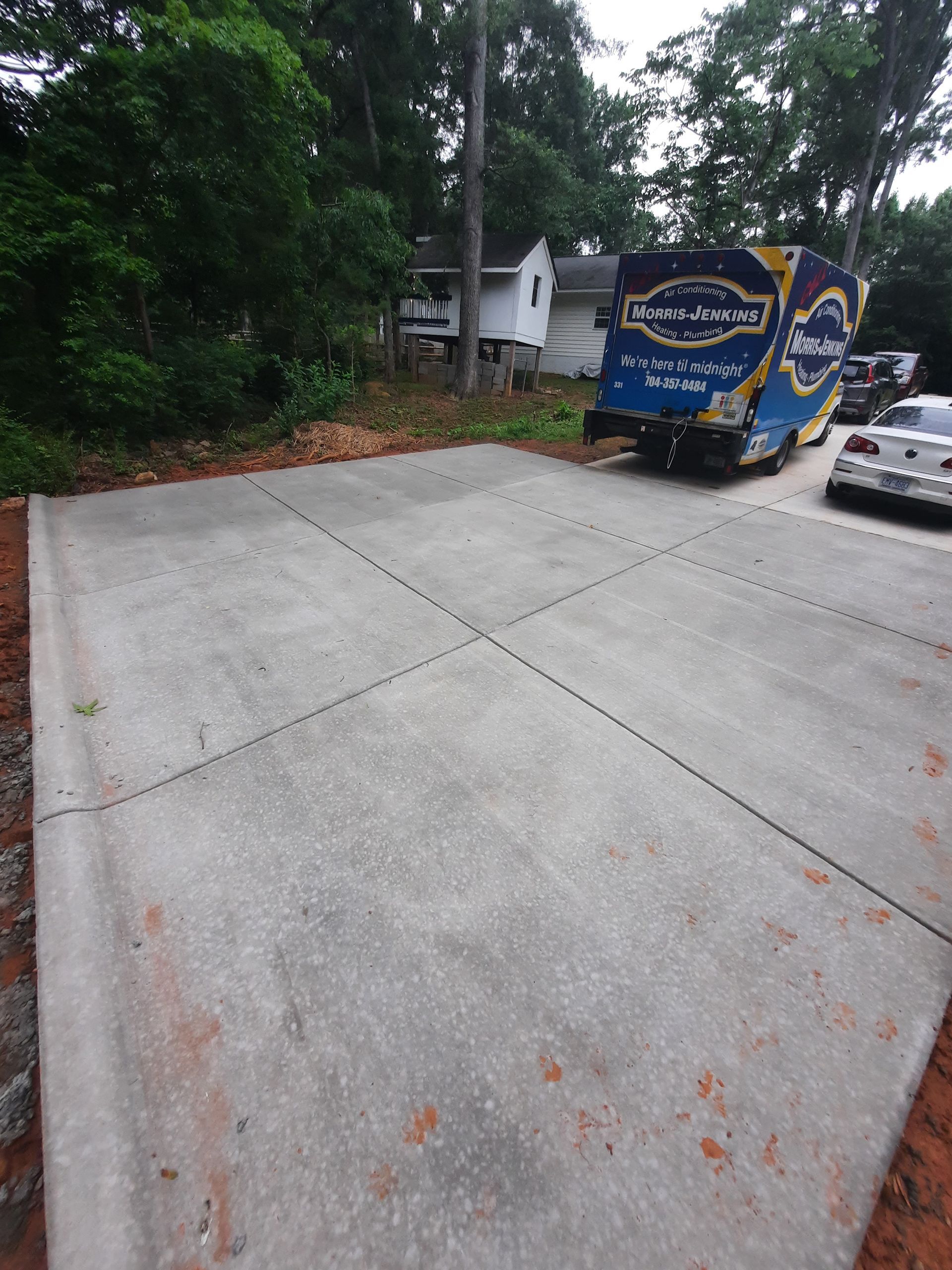 A moving truck is parked in a driveway next to a house.