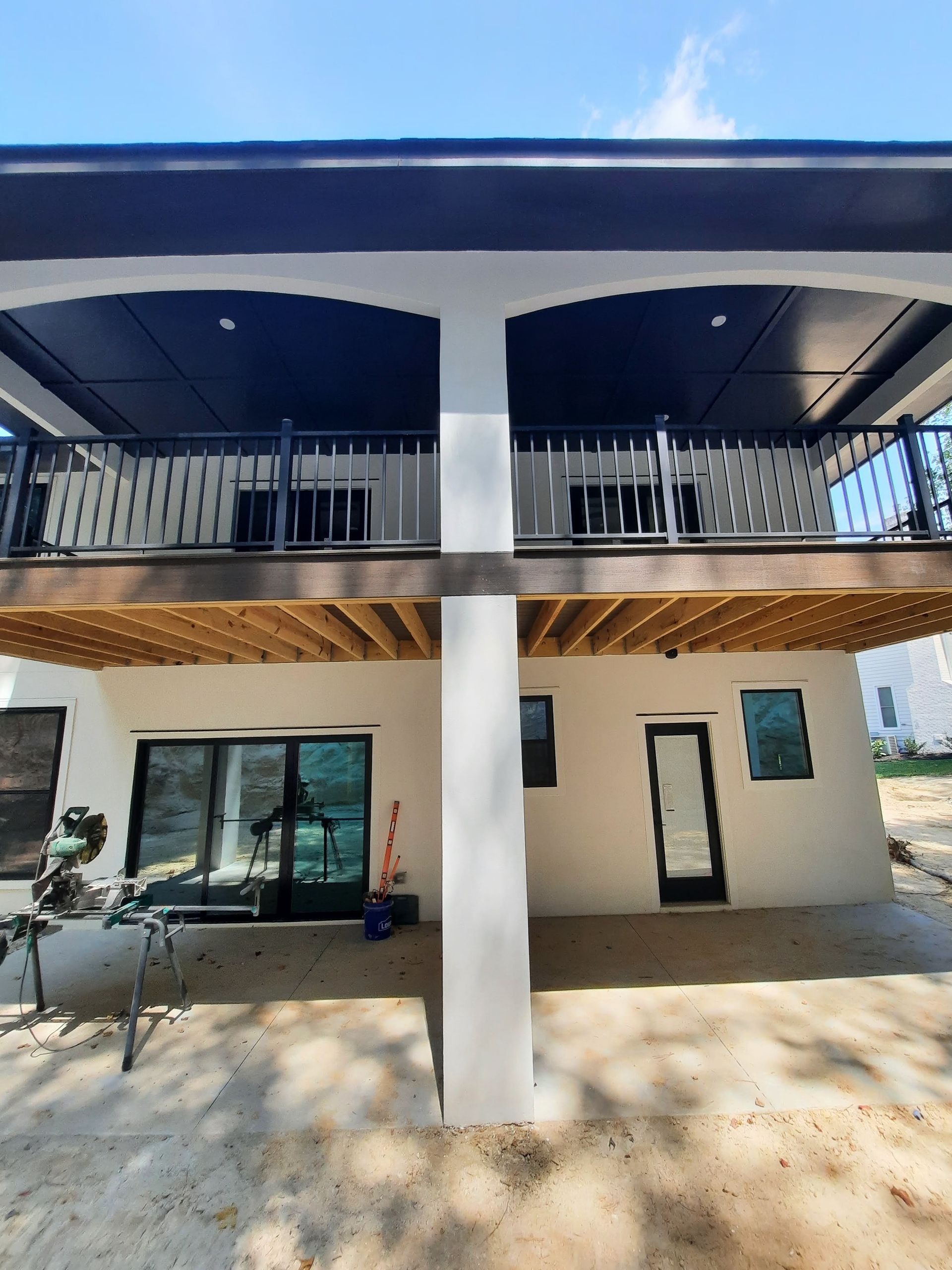 The back of a house with a balcony and a patio.