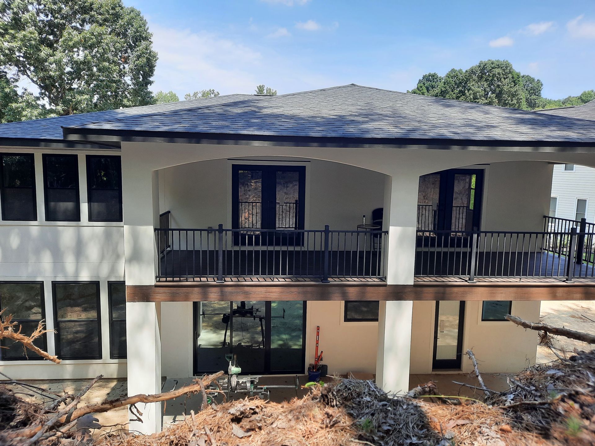 A large white house with a balcony and trees in the background