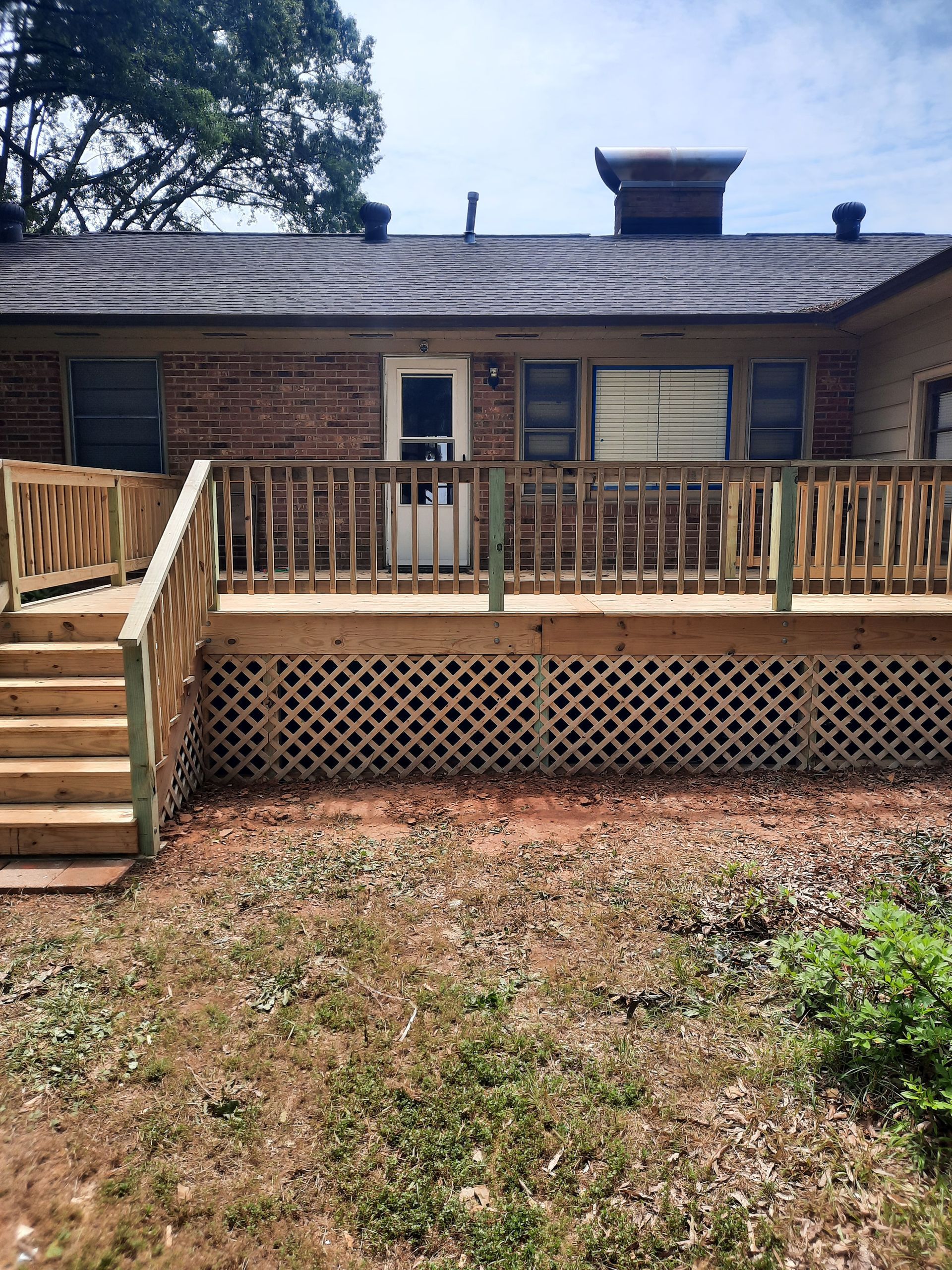 A house with a wooden deck and stairs in front of it