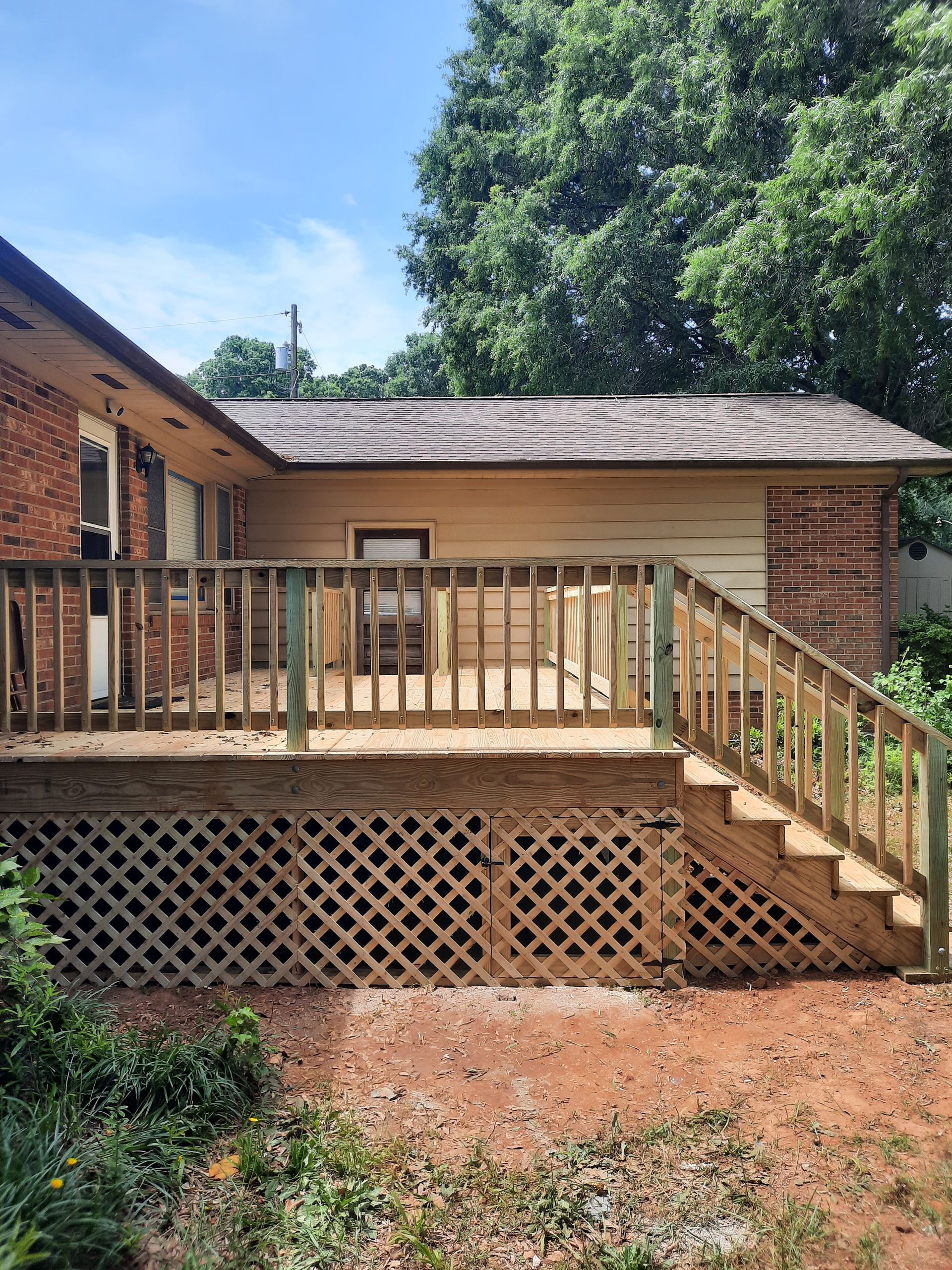 A house with a wooden deck and stairs leading up to it.