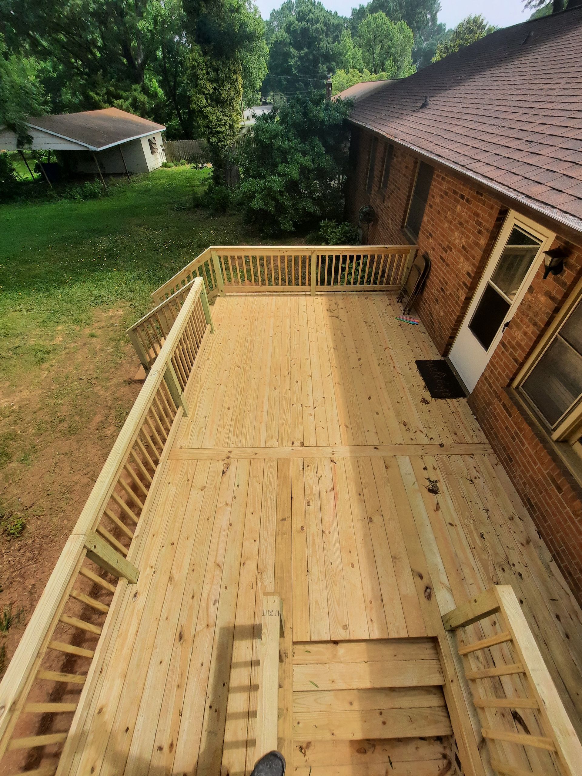 A wooden deck is being built on top of a brick house.