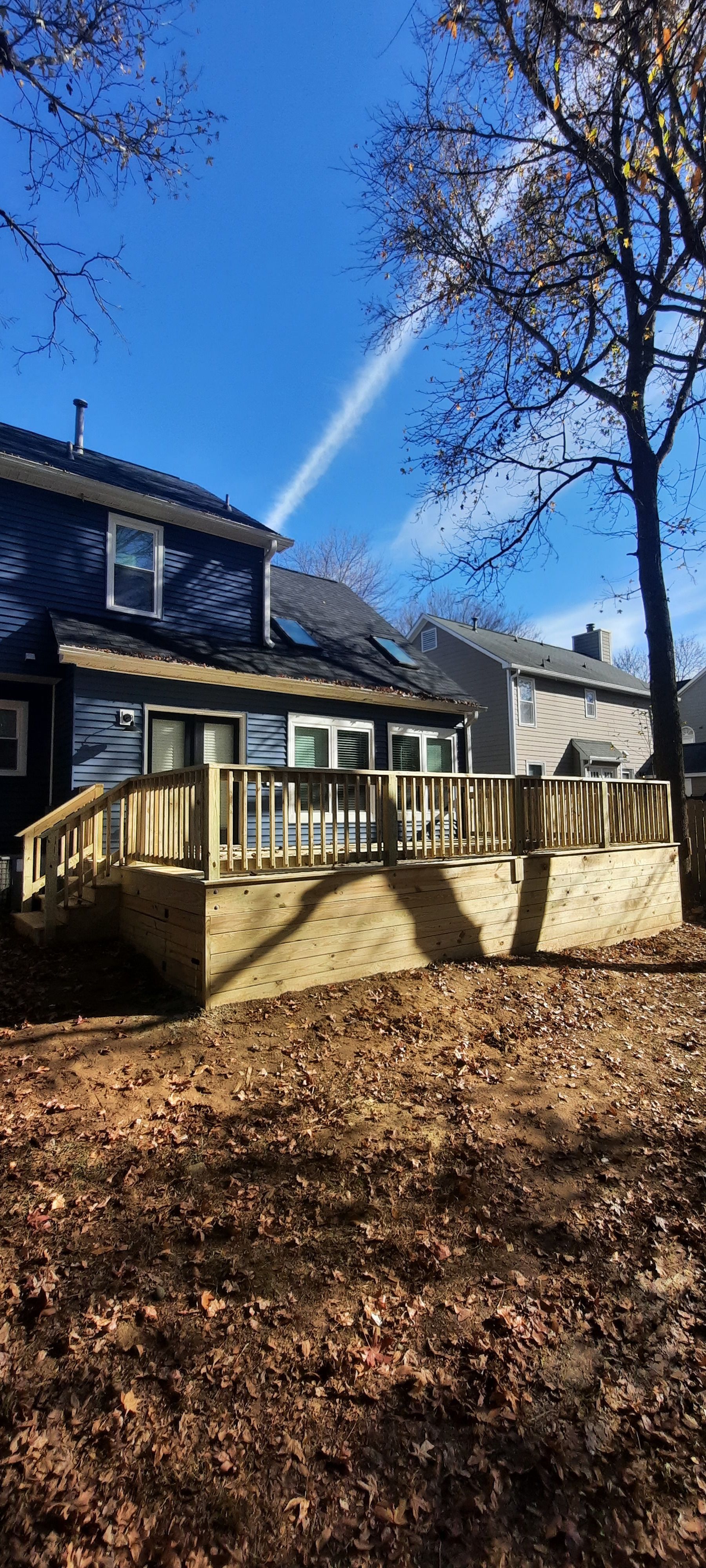 A house with a wooden deck is being sprayed with water.
