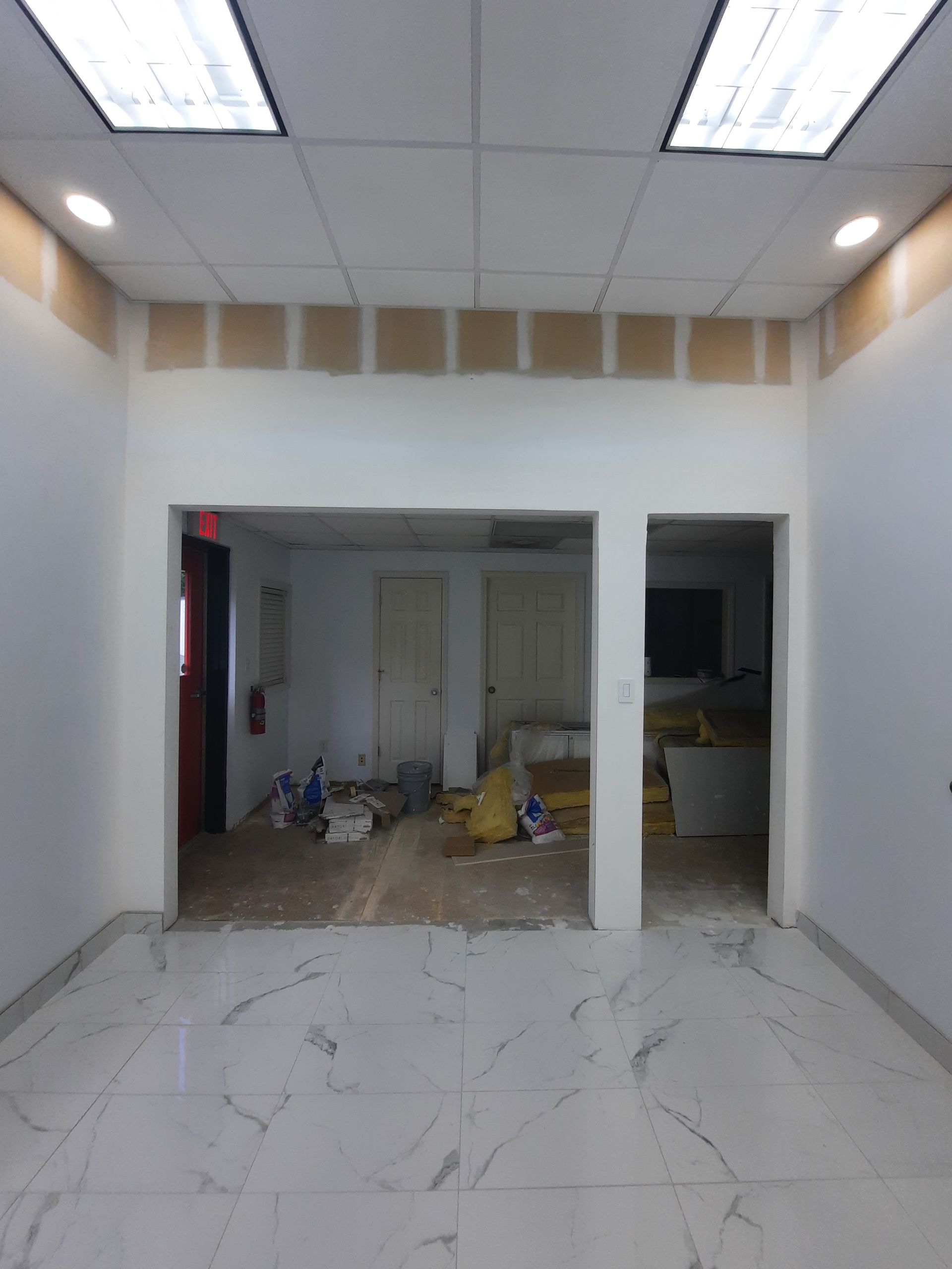 An empty room with a marble floor and white walls