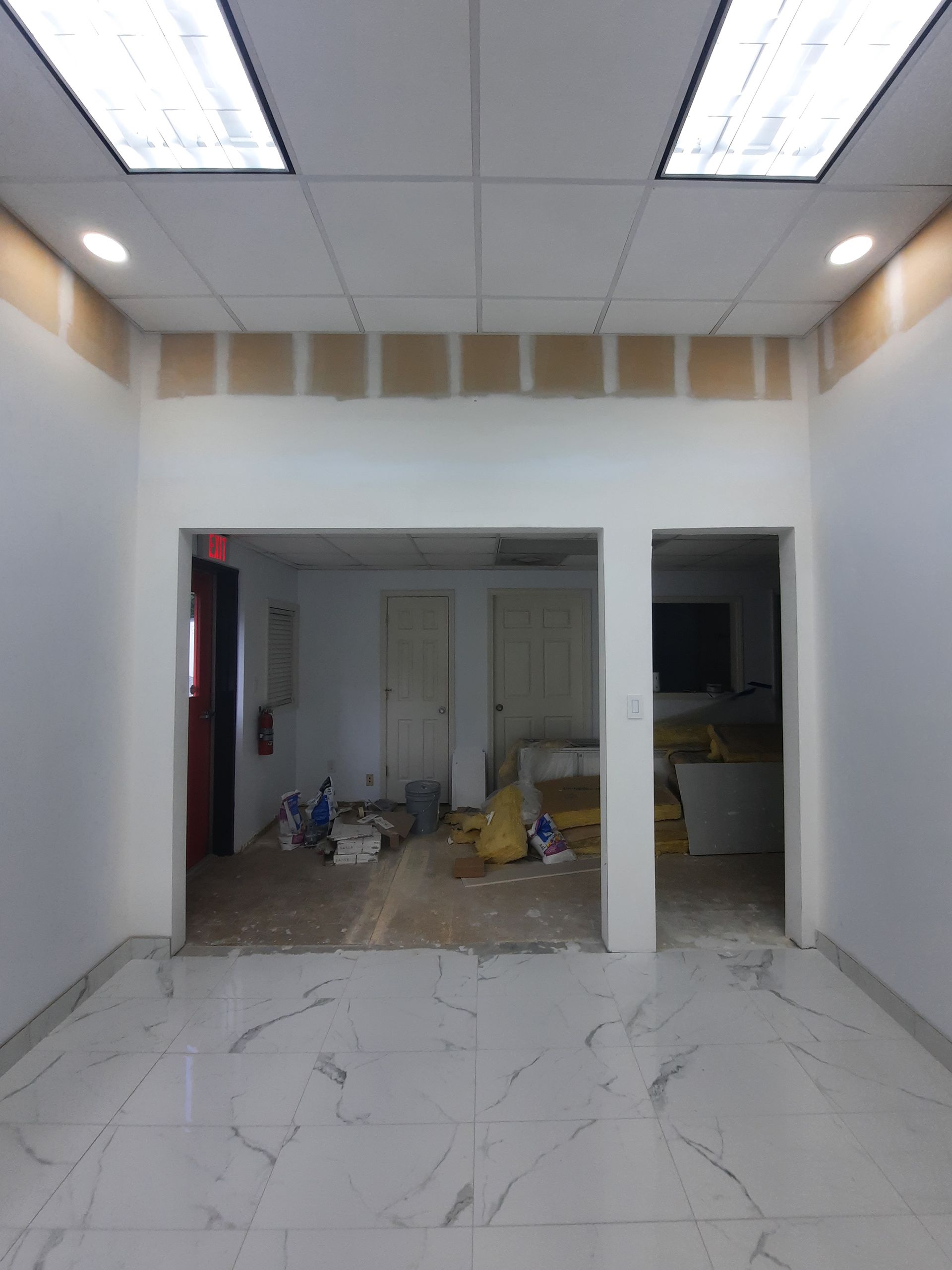 An empty room with a marble floor and white walls