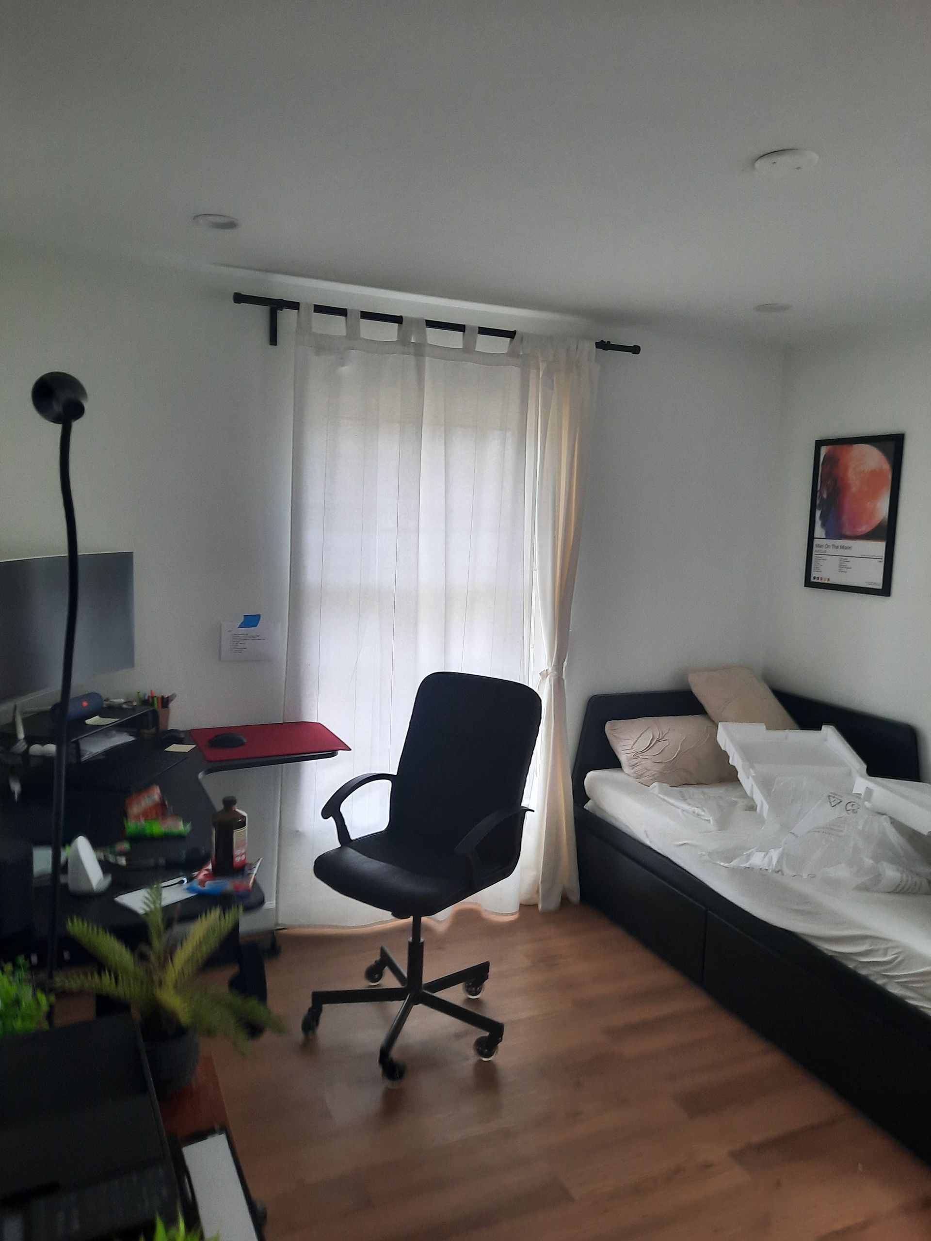 A bedroom with a bed a desk and a chair