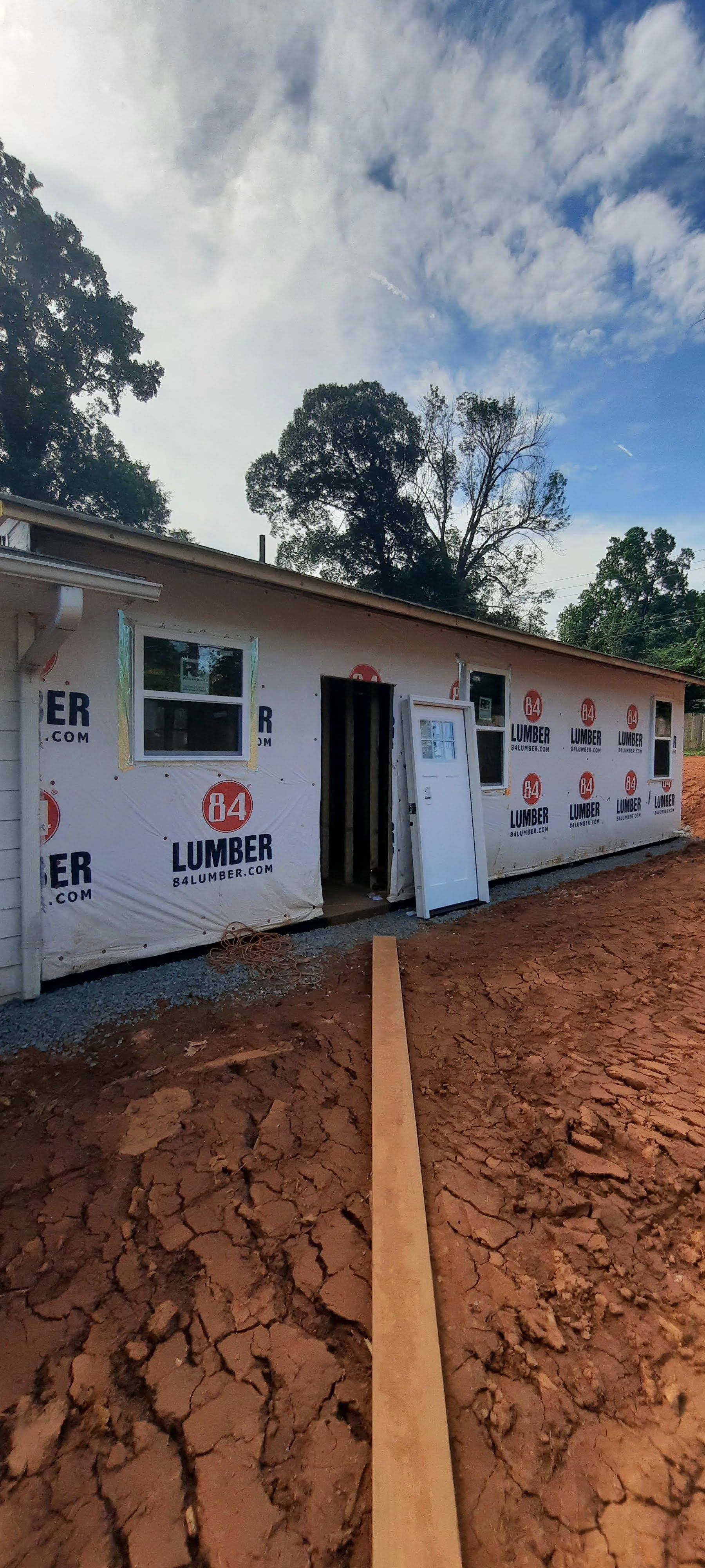 A house is being built in the middle of a dirt field.