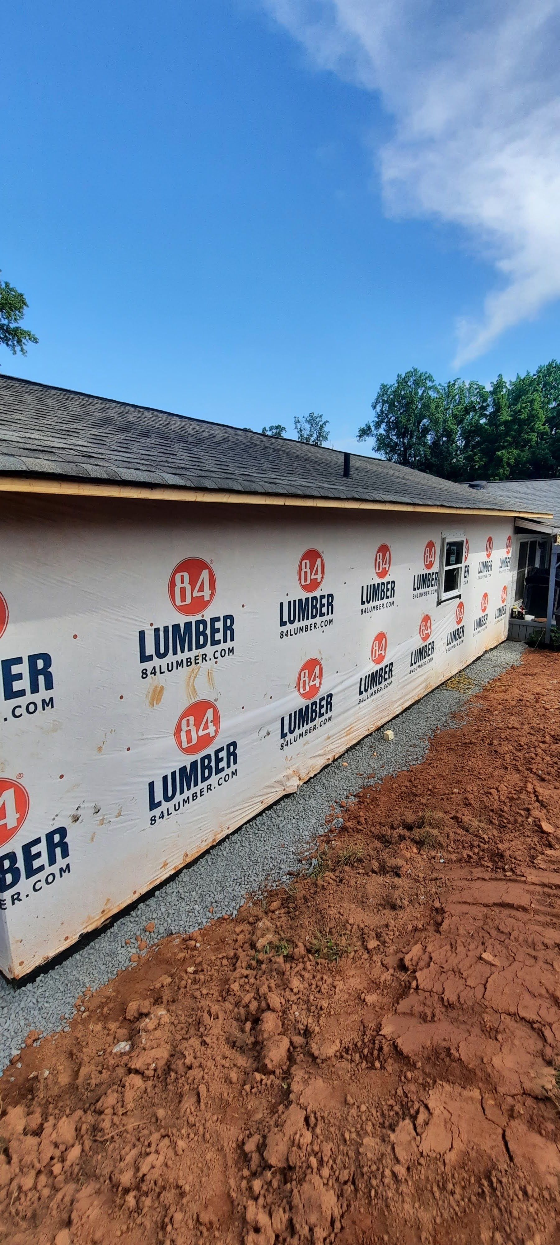 A house is being built with a lot of lumber on the side of it.