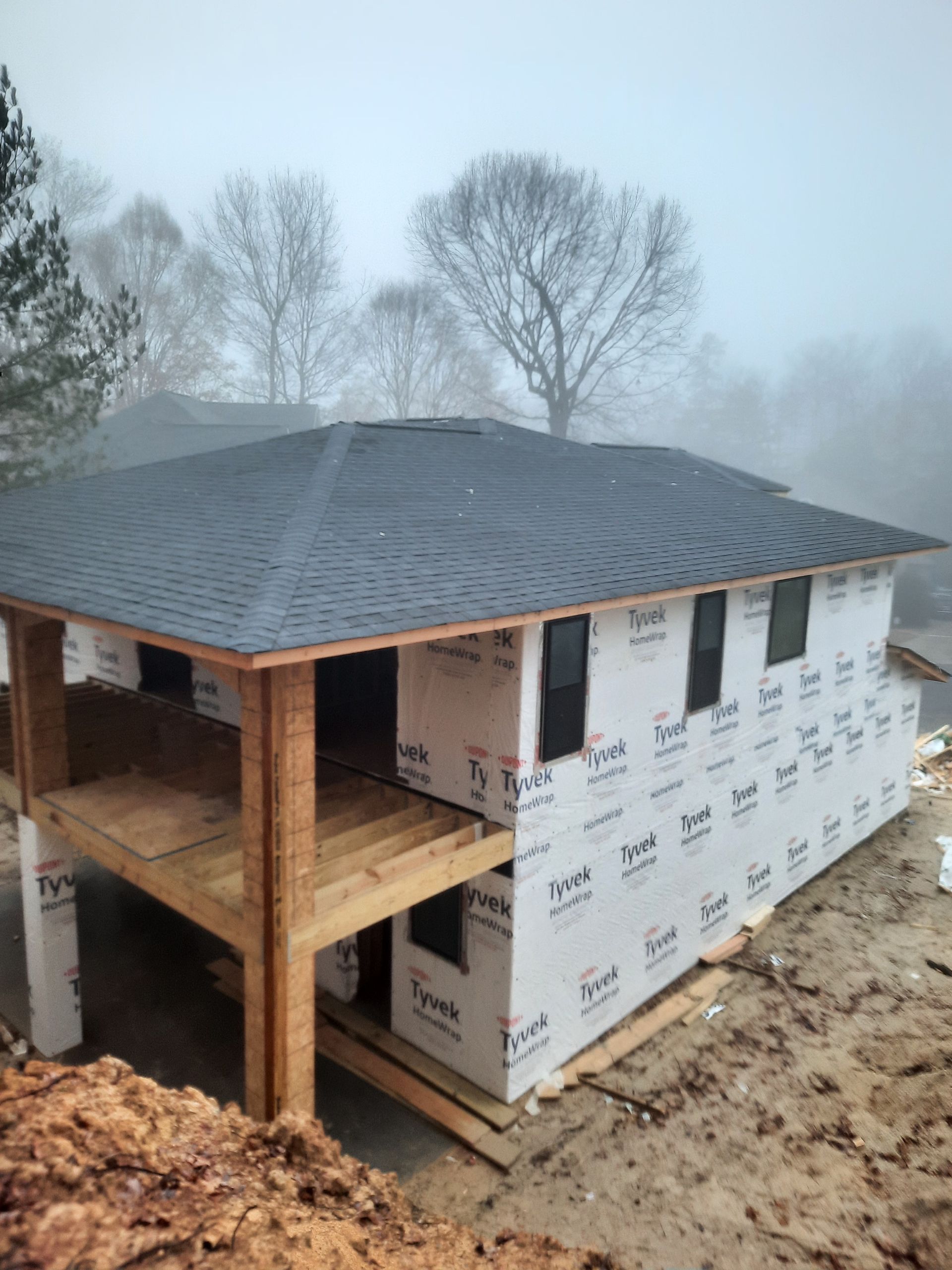 A house under construction with a roof that is covered in shingles.