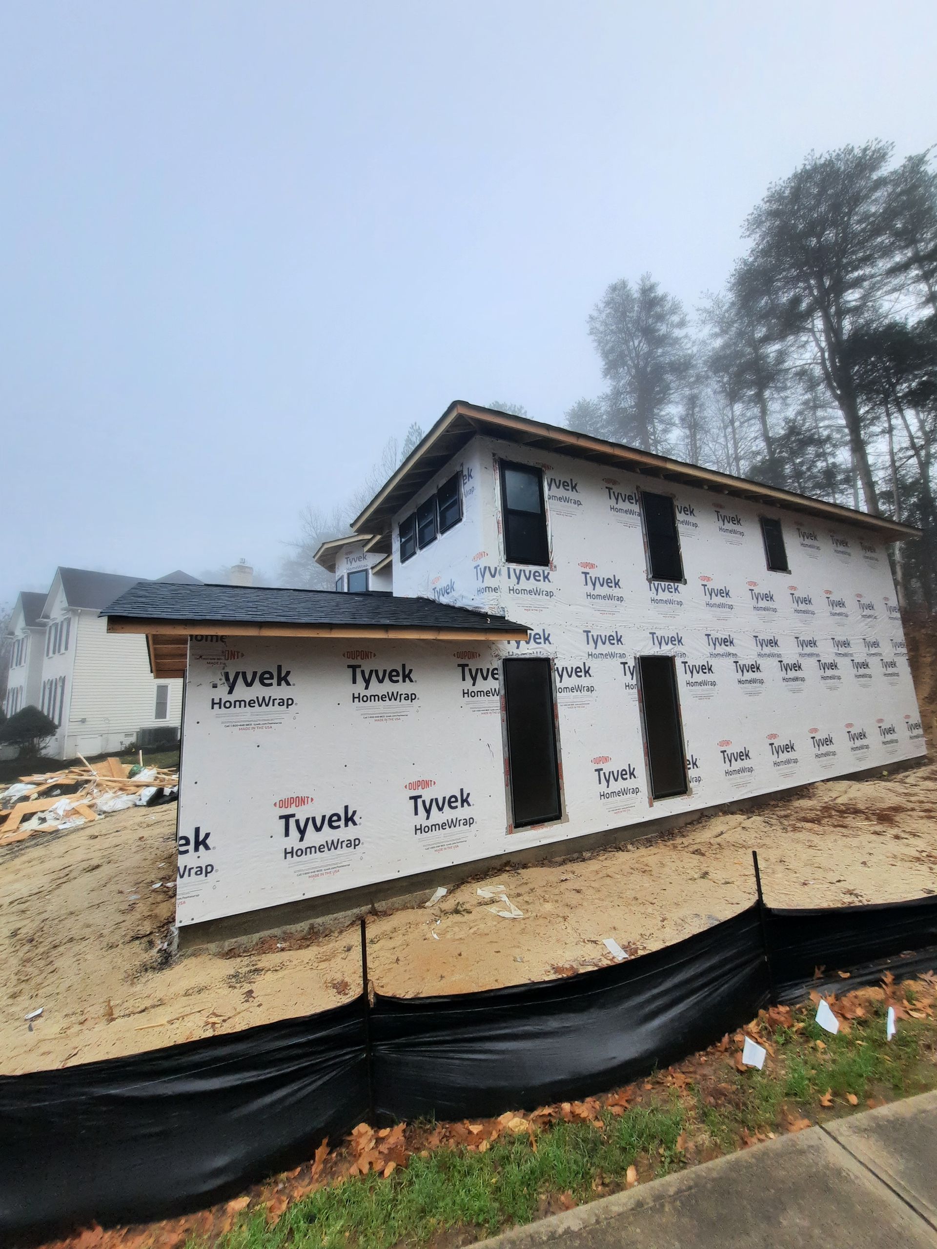 A house is being built on a foggy day.