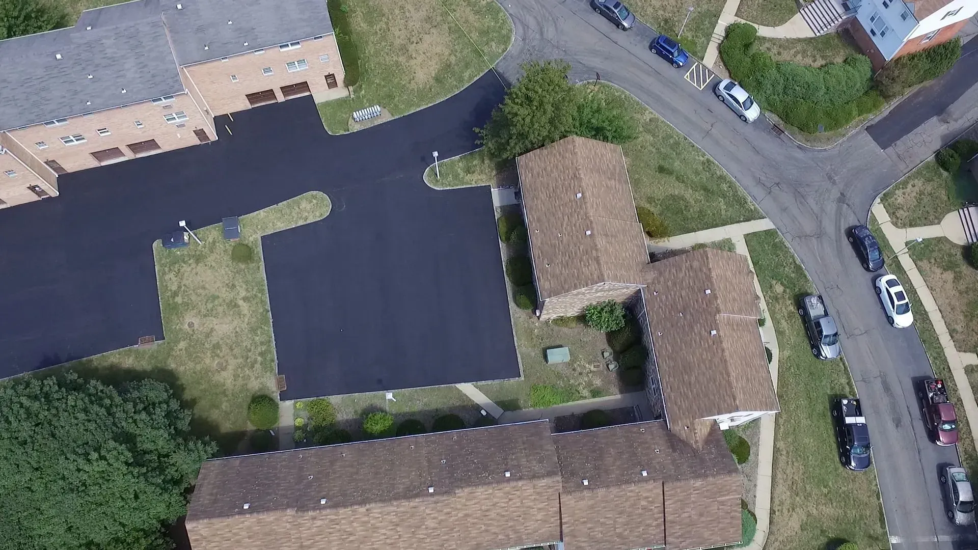 Overhead view of buildings, parking areas, and roadways in a residential neighborhood.