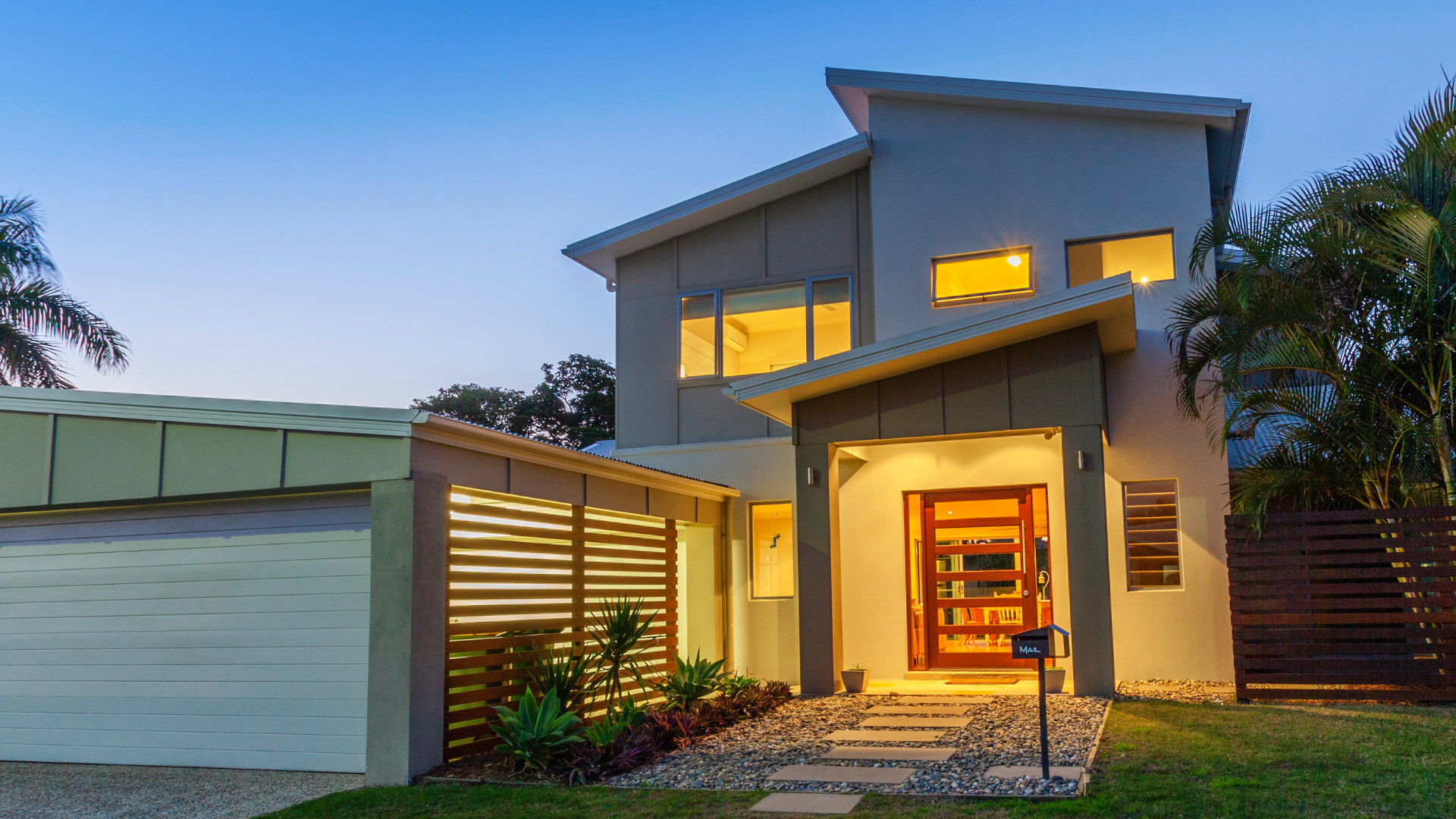 A large house with a lot of windows is lit up at night.